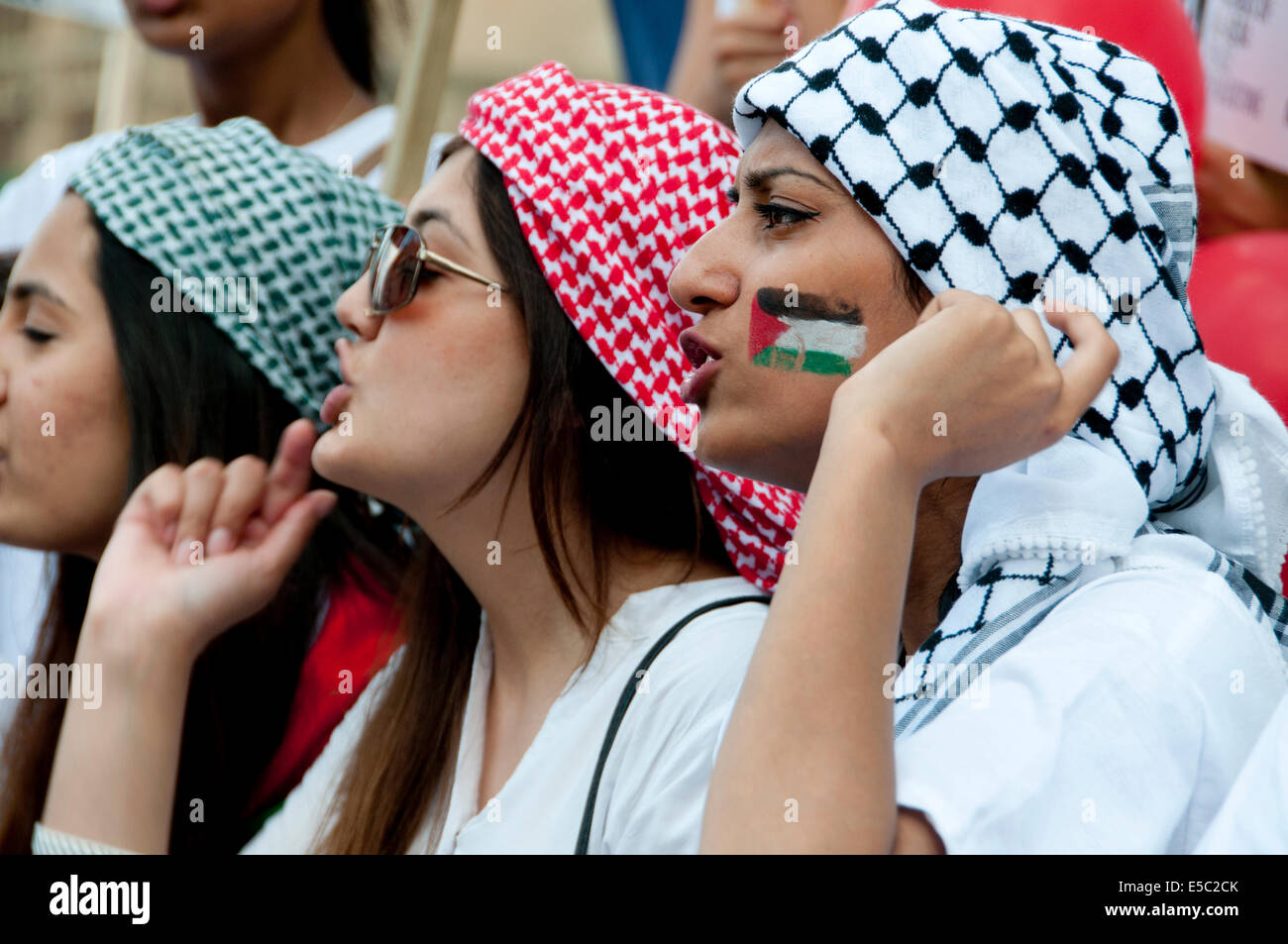 Demonstration against Israeli bombing of Gaza, 26.07.2014. Young women shout, one has a Palestinian flag painted on her face. Stock Photo