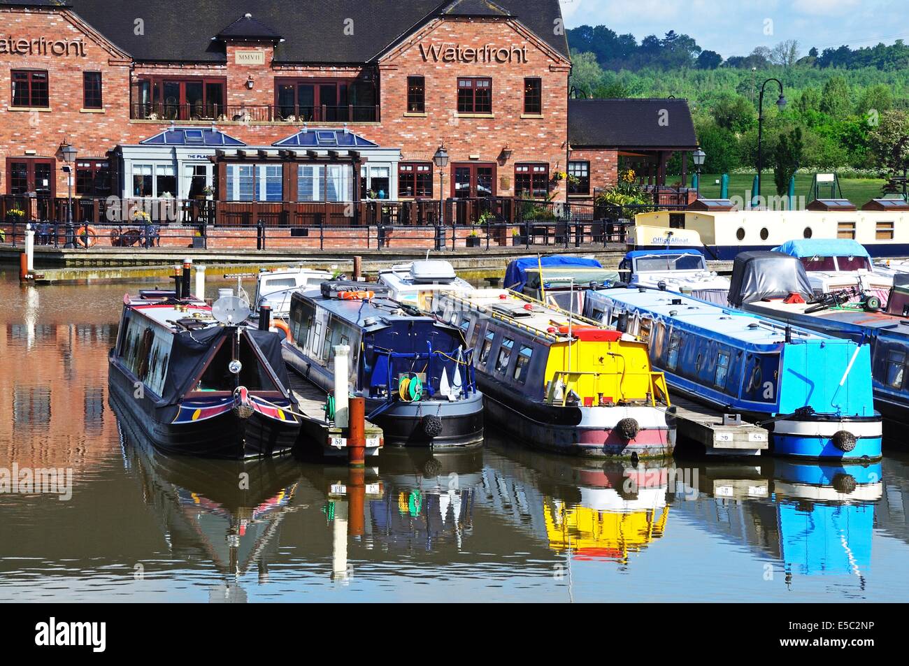 Narrowboats on their moorings in the canal basin with shops, bars and