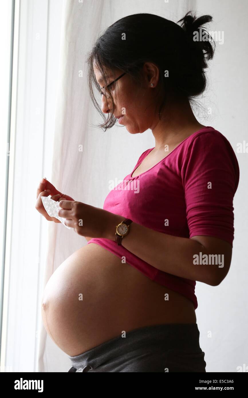 ILLUSTRATION - a nine months pregnant woman holds a package of pills in her hands in Hamburg, Germany, 10 June 2014. Photo: Bodo Marks - MODEL RELEASED -NO WIRE SERVICE- Stock Photo