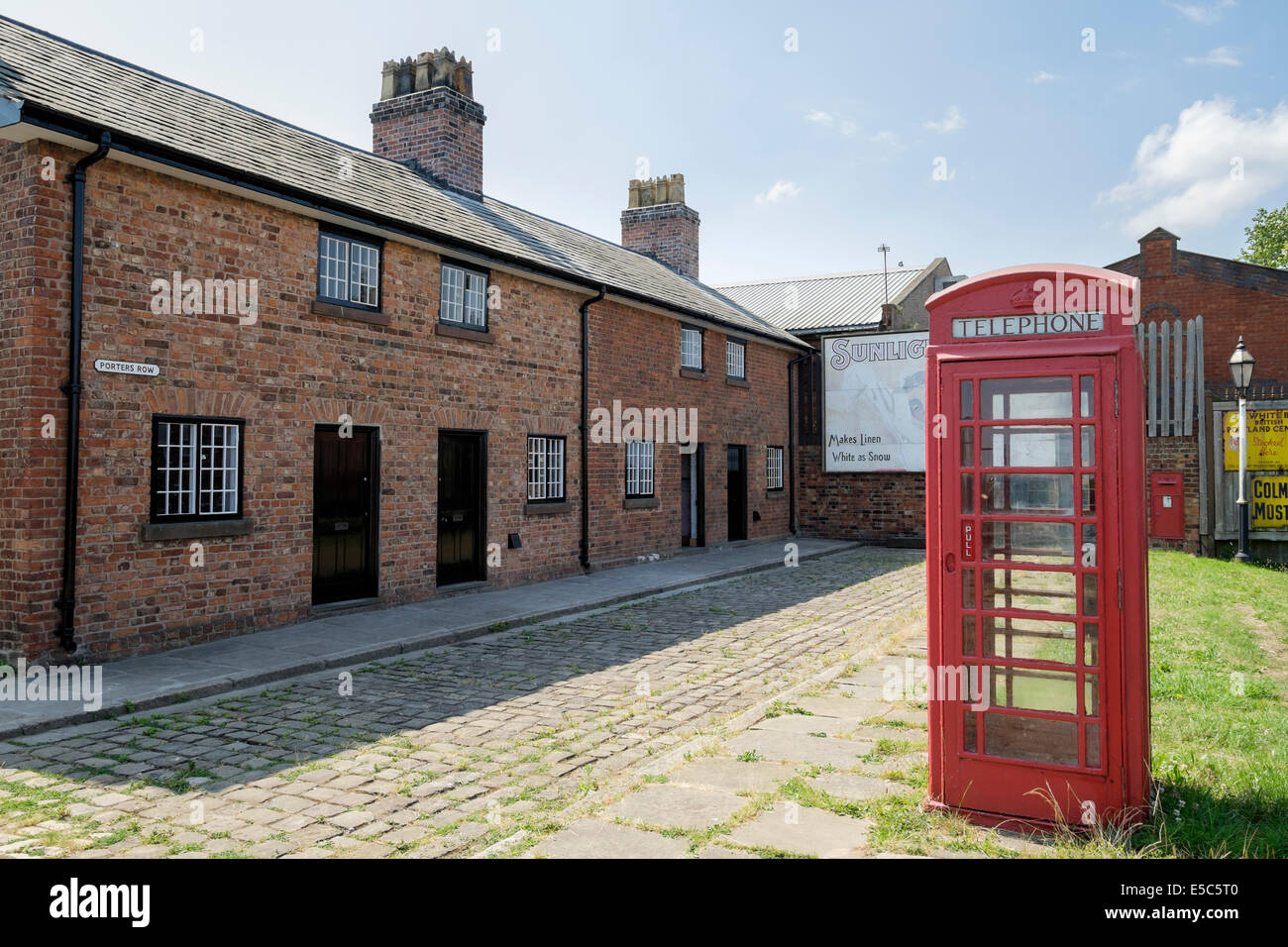 Red phone box in Porters Row of historic cottages housing for dock workers at National Waterways Museum Ellesmere Port Cheshire Stock Photo