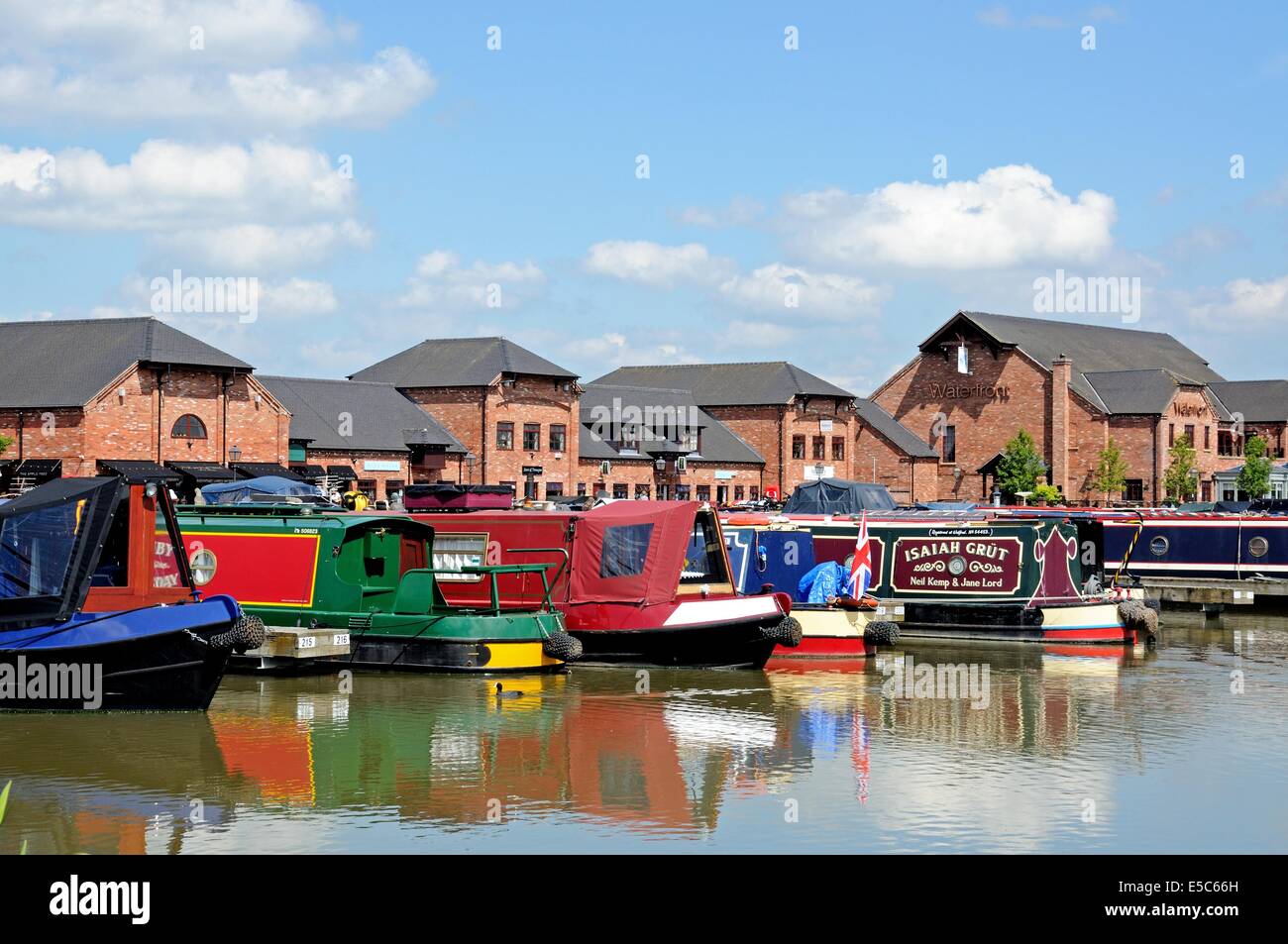Narrowboats on their moorings in the canal basin with shops, bars and
