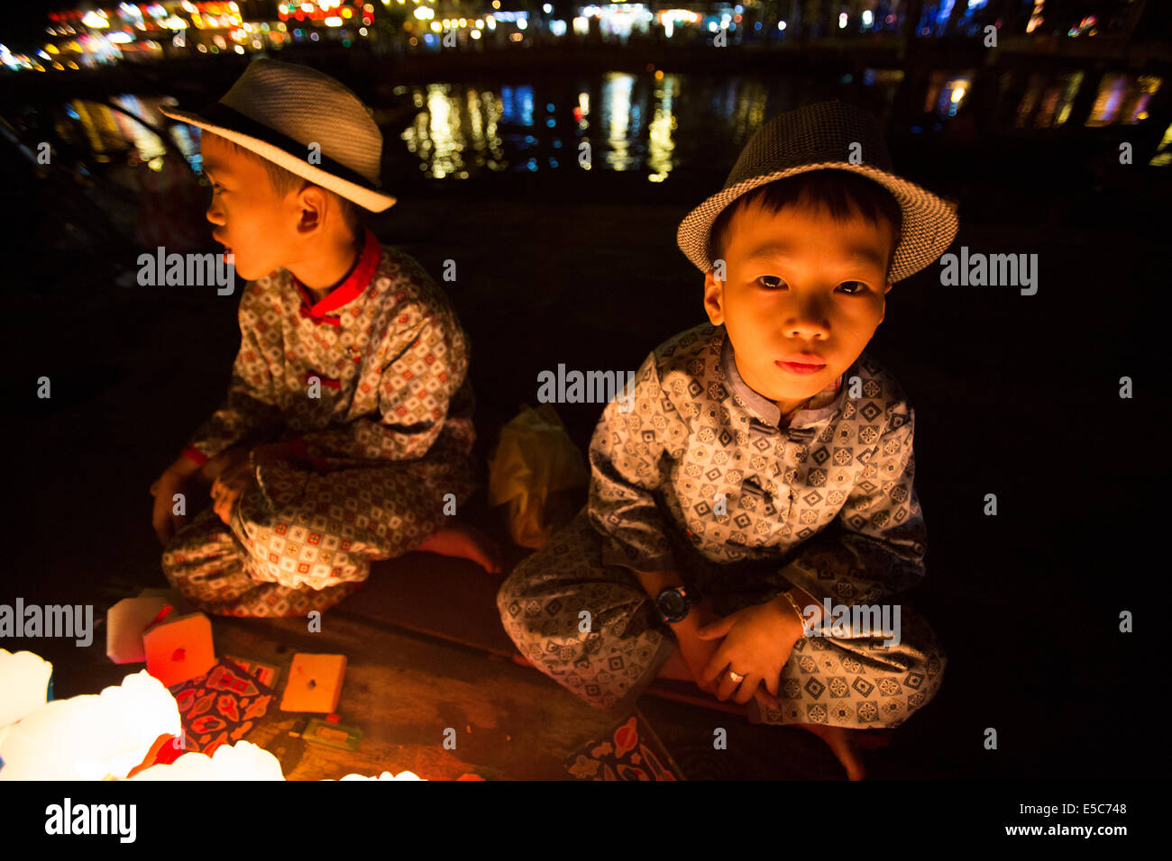 Asian children selling prayer lanterns at night Stock Photo
