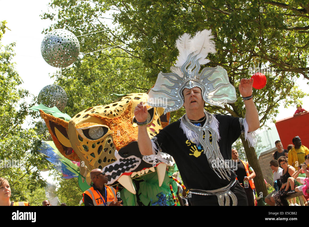 London, UK. 27 July 2014. A man from the Emegency Exit Arts dances in front of a carnival float at the Queen Elizabeth Park in Newham. Credit: David Mbiyu/ Alamy Live News Stock Photo