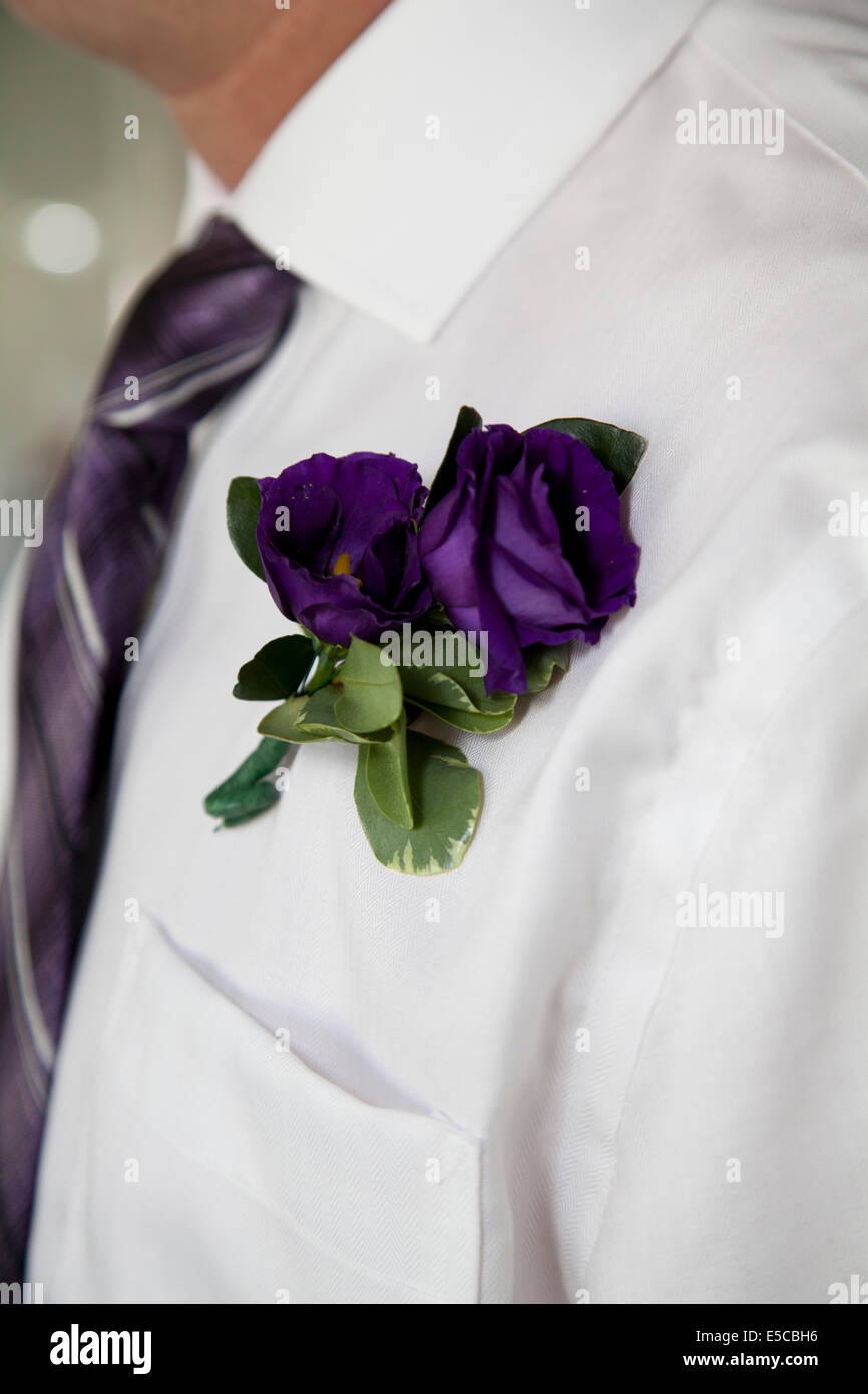 A close up of a beautiful purple boutonnière on a mans chest. Stock Photo