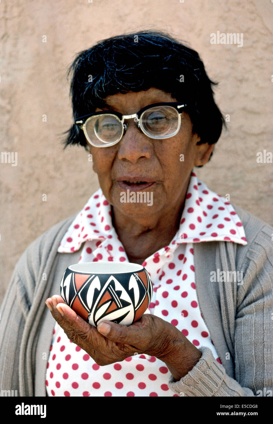 An elderly Native American woman holds a piece of prized pottery that she has handmade in Acoma Pueblo, a remote Indian community in New Mexico, USA. Stock Photo