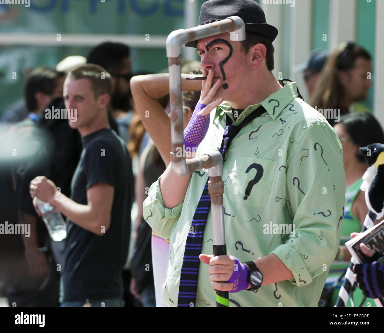 San Diego, California, USA. 26th July, 2014. The Joker smoking outside the San Diego Convention Center.---The 40th Annual 2014 Comic-Con International continued on Saturday July 26, 2014, in its third of four days at the San Diego Convention Center. The Annual event, the biggest of its kind, brings approximately 150,000 sci-fi, anime, horror, cartoon and gaming enthusiasts to San Diego to celebrate with vendor displays and presentations as well as panel discussions as well as celebrity appearances for book signings and talks. © David Bro/ZUMA Wire/Alamy Live News Stock Photo