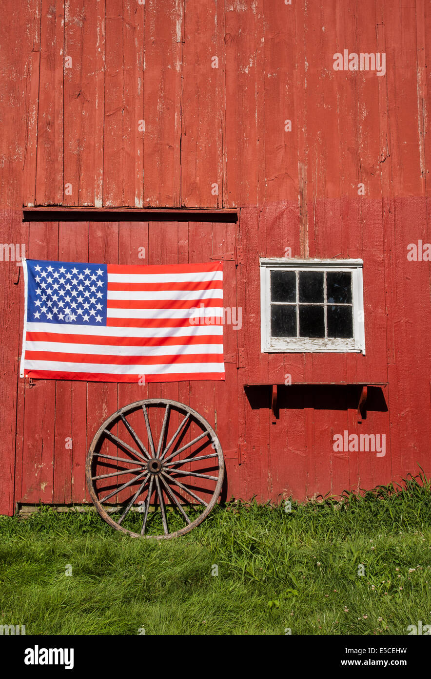 Fourth of July American flag on a close up vintage red barn on a farm in Monroe Township, New Jersey, USA, vertical farming old, US flag close up Stock Photo