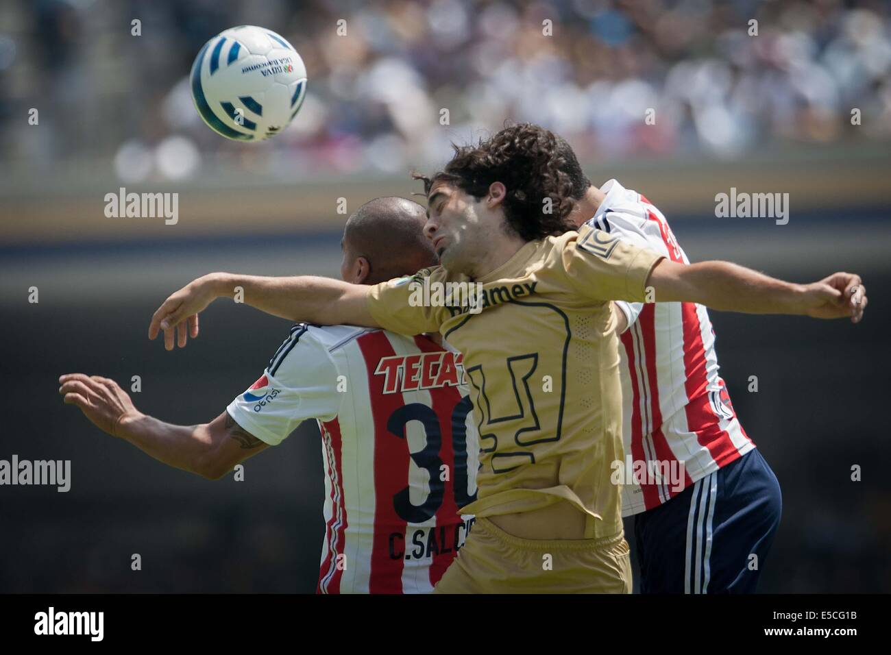 Mexico City, Mexico. 27th July, 2014. Matias Britos (C) of Pumas de la UNAM vies the ball with Carlos Salcido (L) of Chivas, during a match of the Opening Tournament 2014 of the MX League, celebrated in the University Olympic Stadium, in Mexico City, capital of Mexico, on July 27, 2014. © Pedro Mera/Xinhua/Alamy Live News Stock Photo