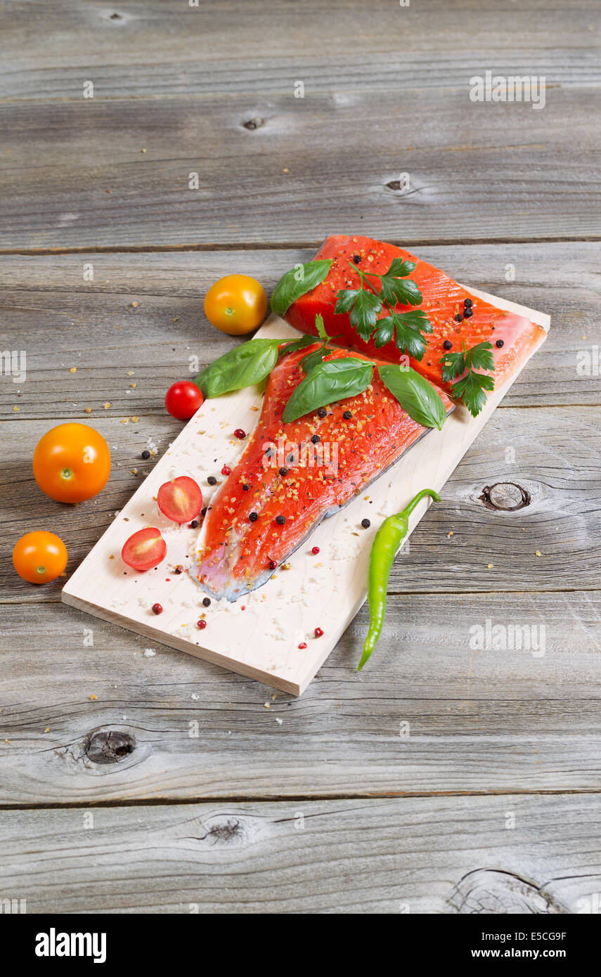 Vertical view of raw red salmon, skin side down, on maple wood grilling
