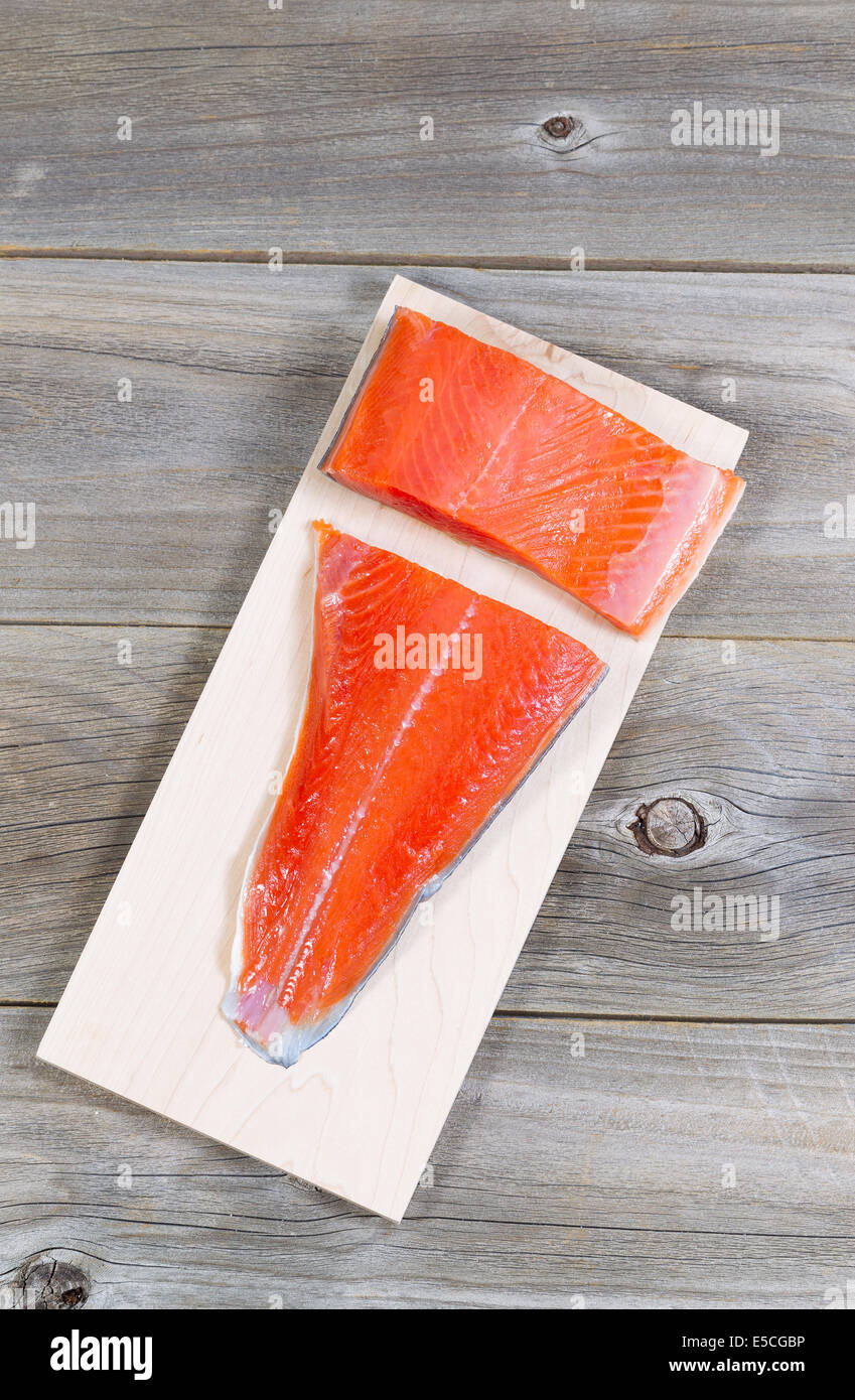 Vertical top view of raw red salmon, skin side down, on maple wood