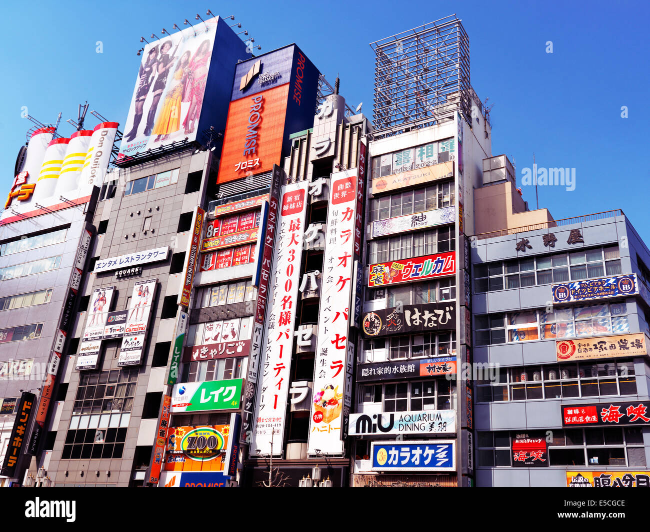 Buildings with store and restaurant signs on Yasukuni Dori, Shinjuku, Tokyo, Japan 2014 Stock Photo