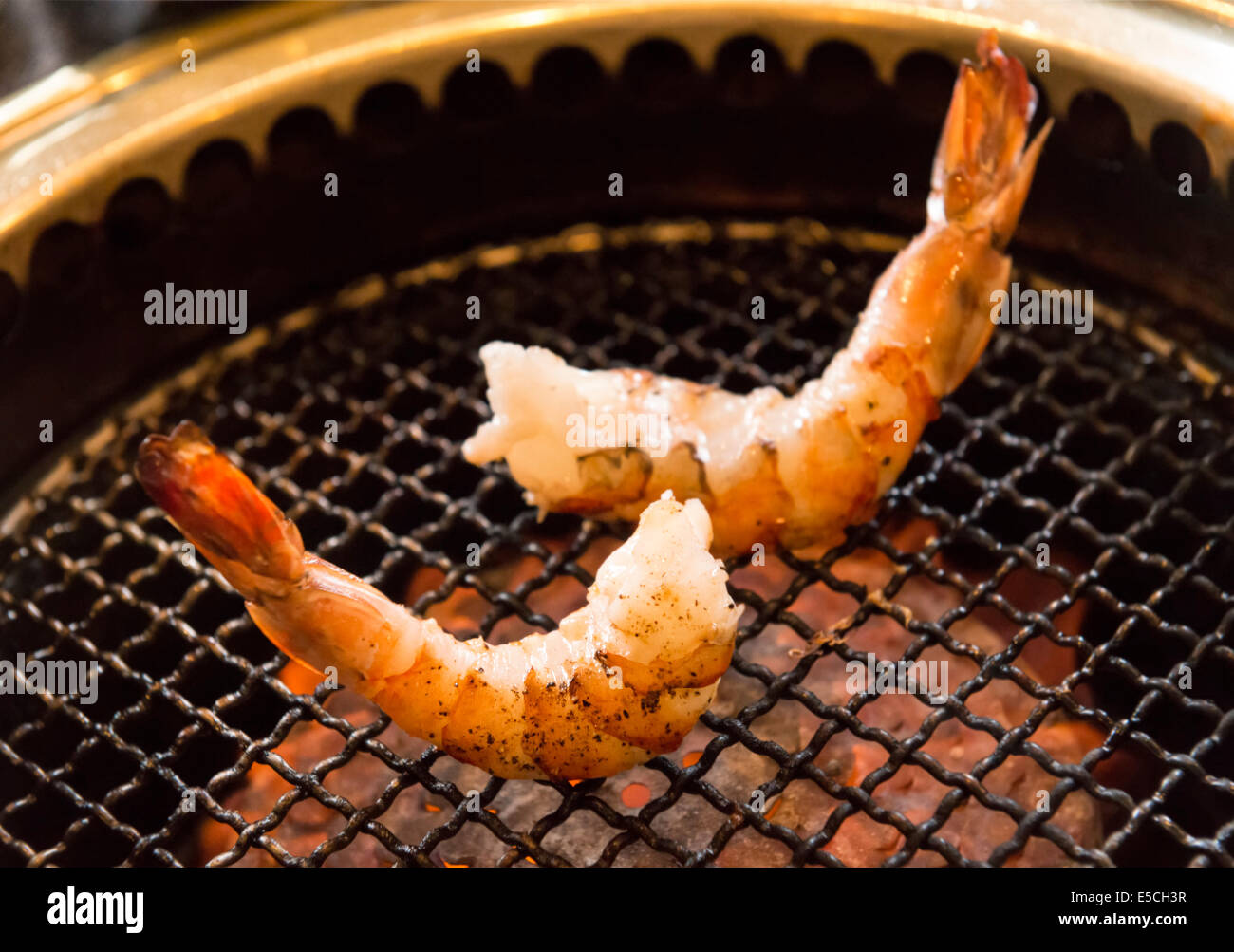 Closeup of shrimps being cooked on a Japanese grill stove at a restaurant Stock Photo