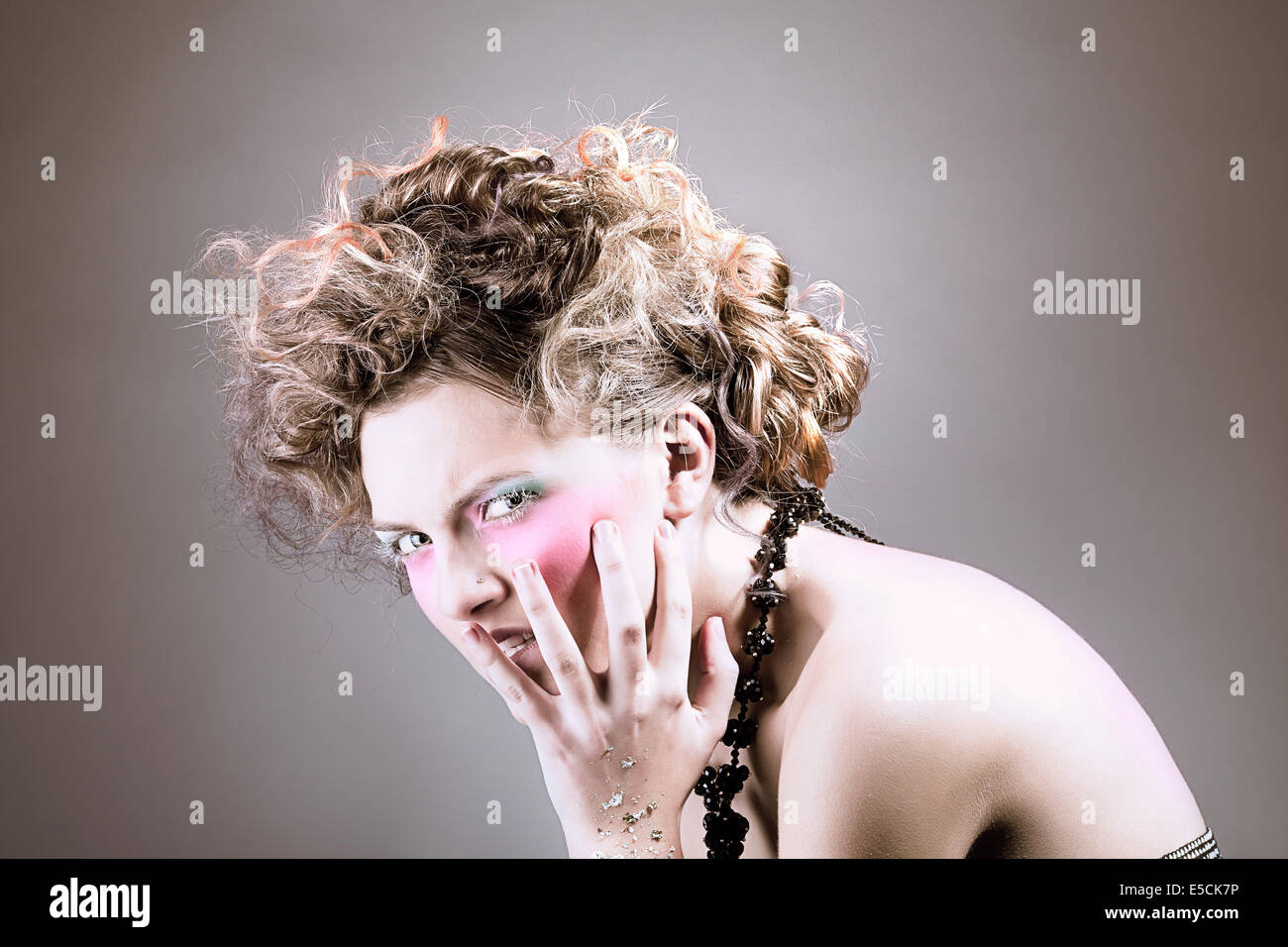 Beautiful woman with curly hairstyle and pink make up Stock Photo - Alamy