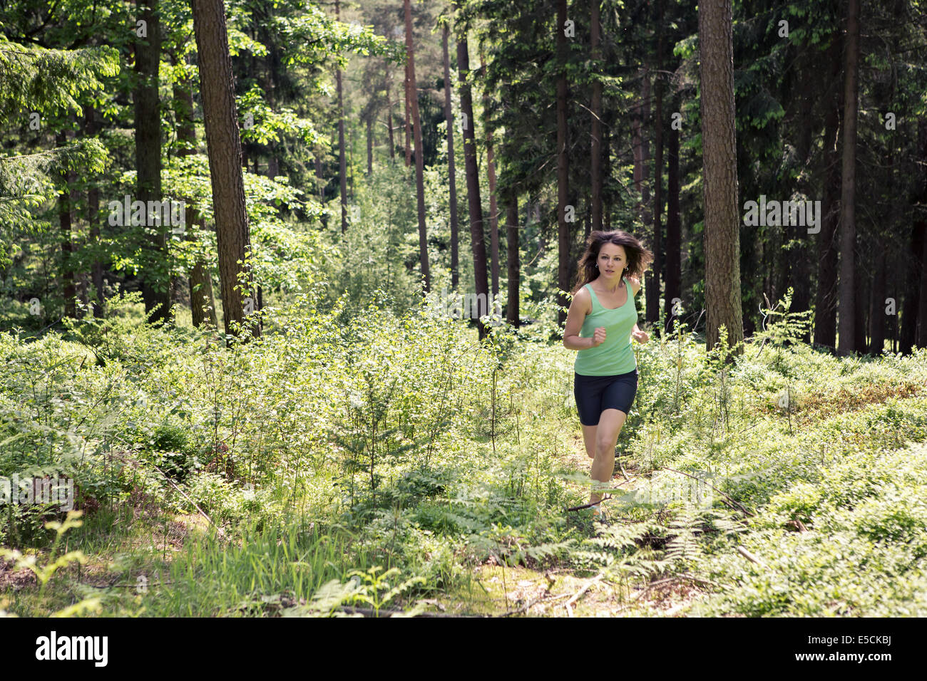 young woman jogging in a forest Stock Photo - Alamy