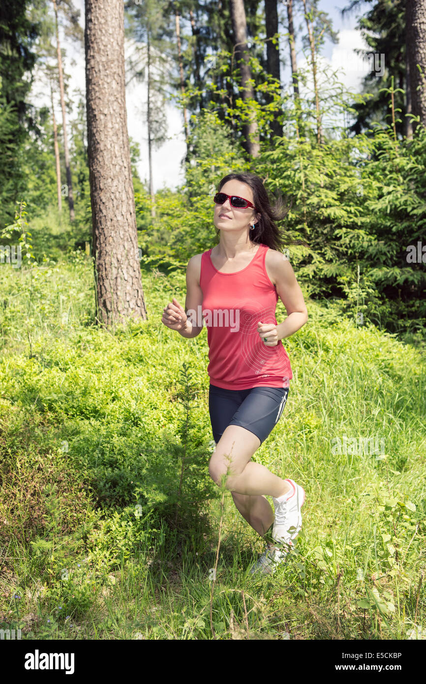 young woman jogging in a forest Stock Photo - Alamy
