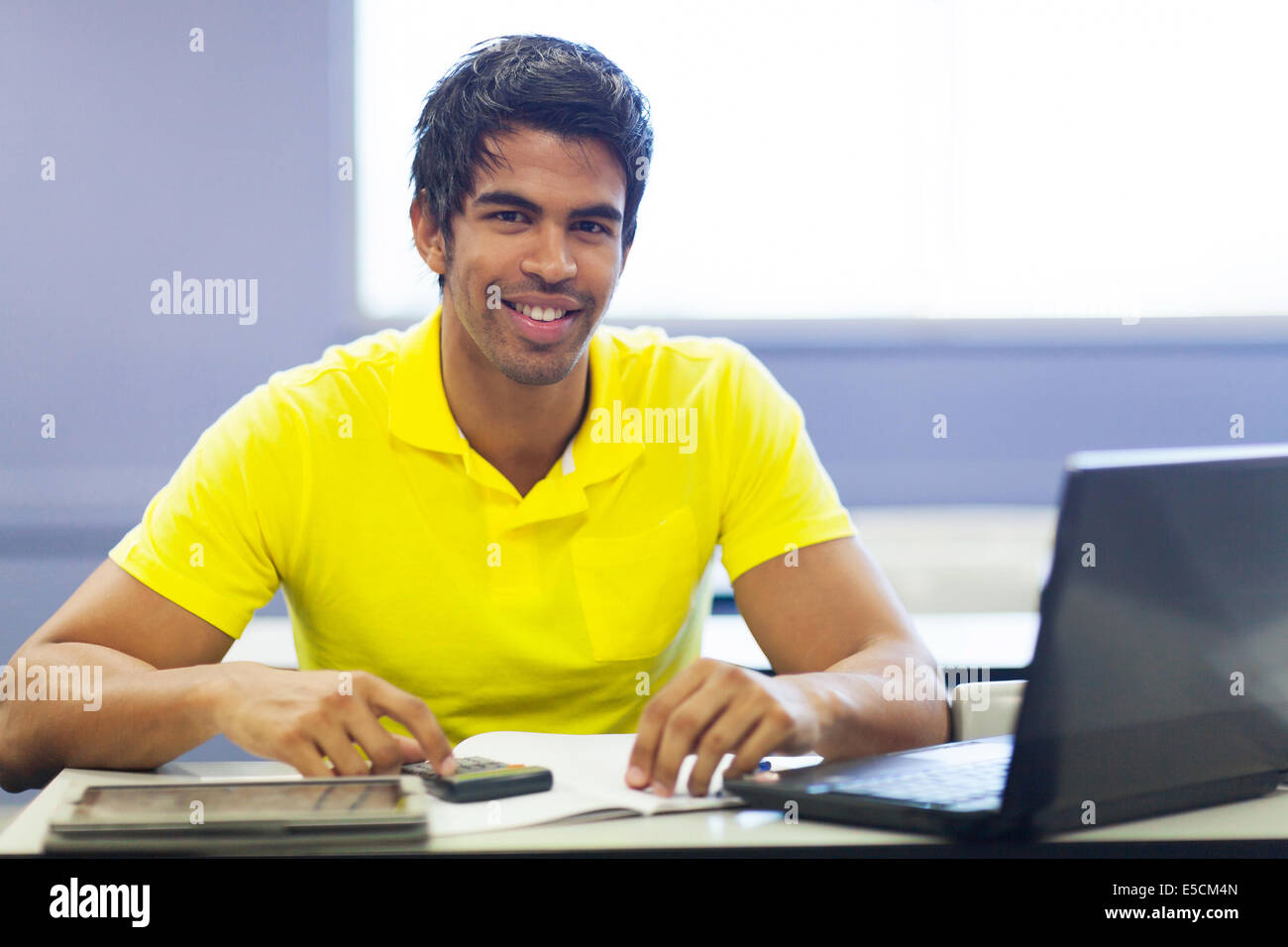 cheerful male Indian college student in lecture room Stock Photo