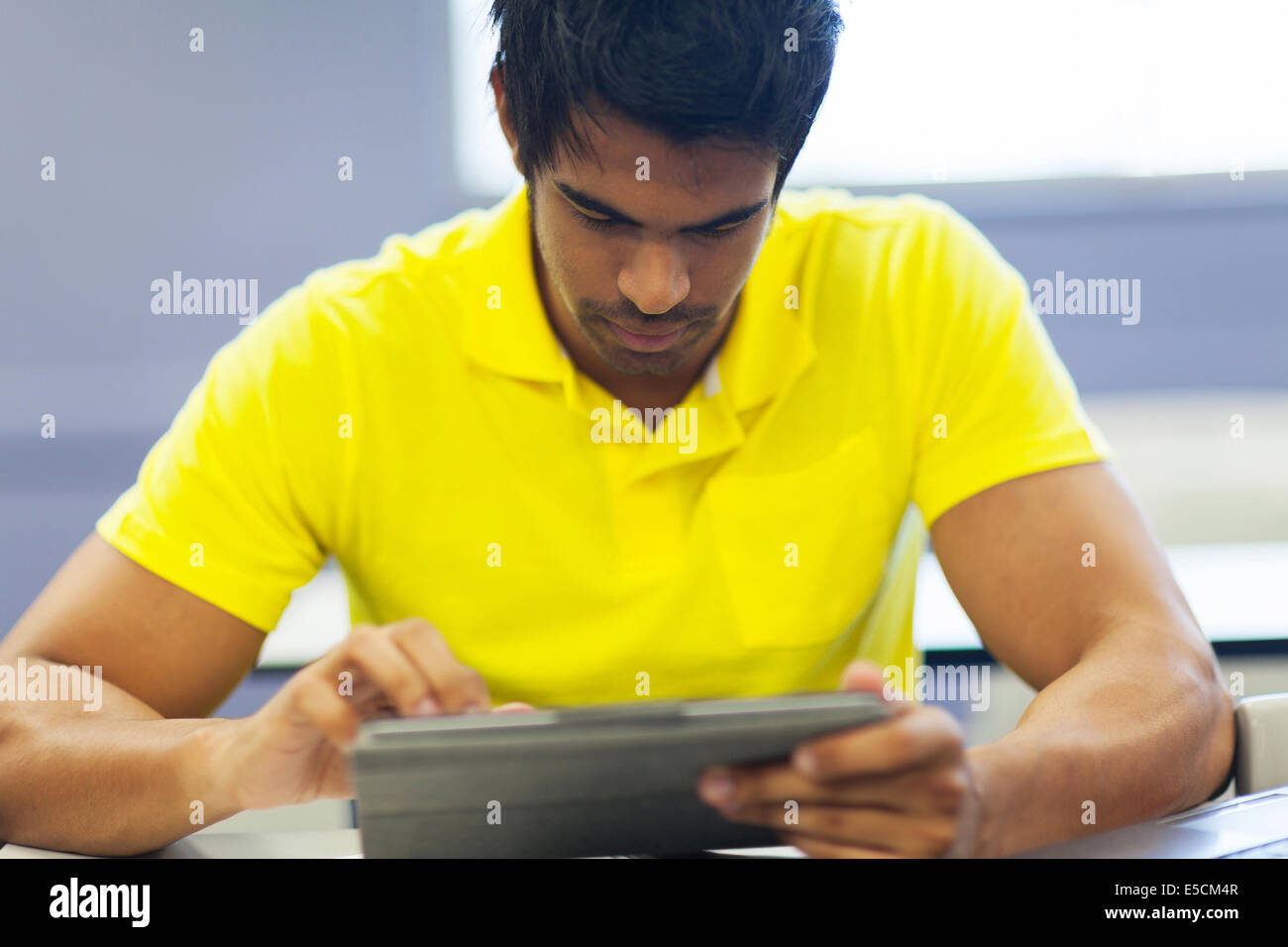 close up portrait of male Indian college student using tablet computer Stock Photo