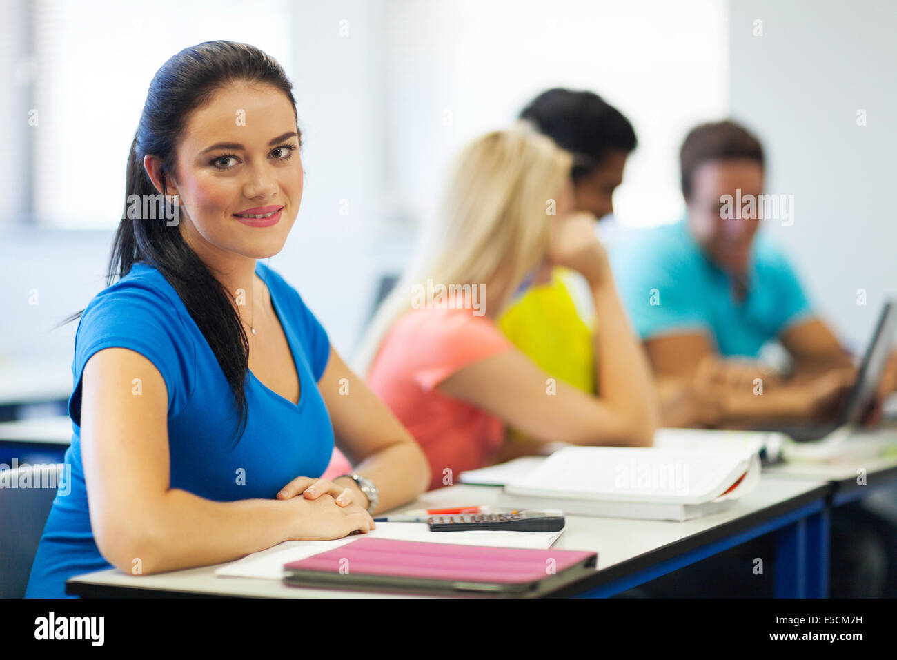 beautiful young college girl in lecture hall looking at the camera ...