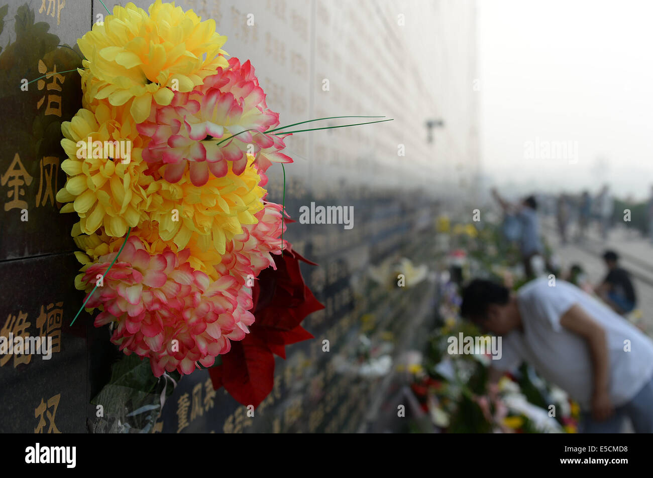 Tangshan, China's Hebei Province. 28th July, 2014. Paper flowers are seen on the memorial wall of the 1976 Tangshan earthquake in Tangshan, north China's Hebei Province, July 28, 2014. Local residents came to the memorial park on Monday to commemorate the 38th anniversary of the Tangshan earthquake. © Zheng Yong/Xinhua/Alamy Live News Stock Photo