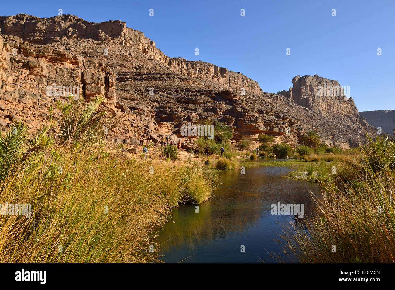 Group of people hiking in Iherir Canyon, Tassili n'Ajjer National Park, Unesco World Heritage Site, Sahara desert, Algeria Stock Photo