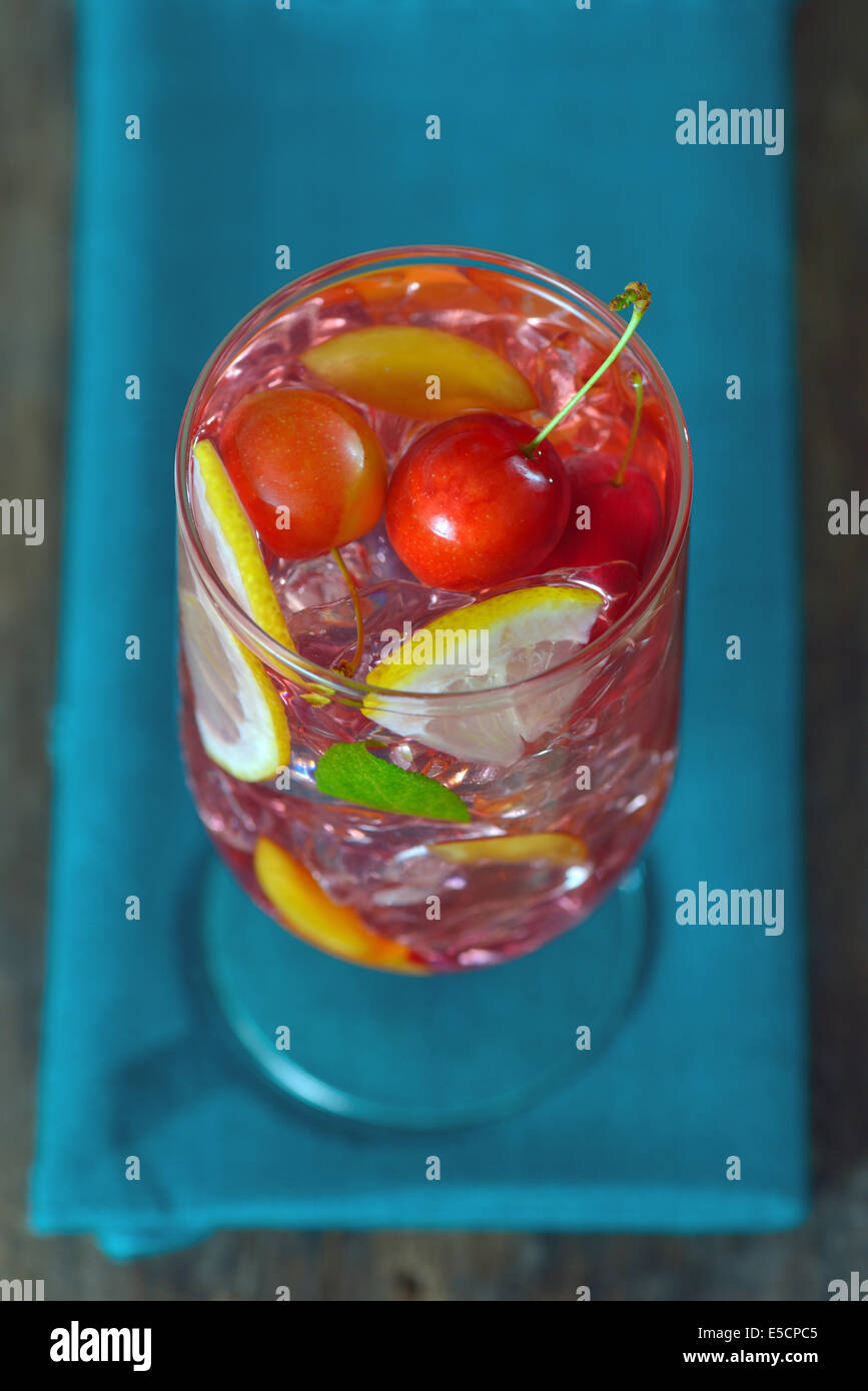 Cherry plum cocktail with ice, mint and lemon isolated. Above Stock Photo