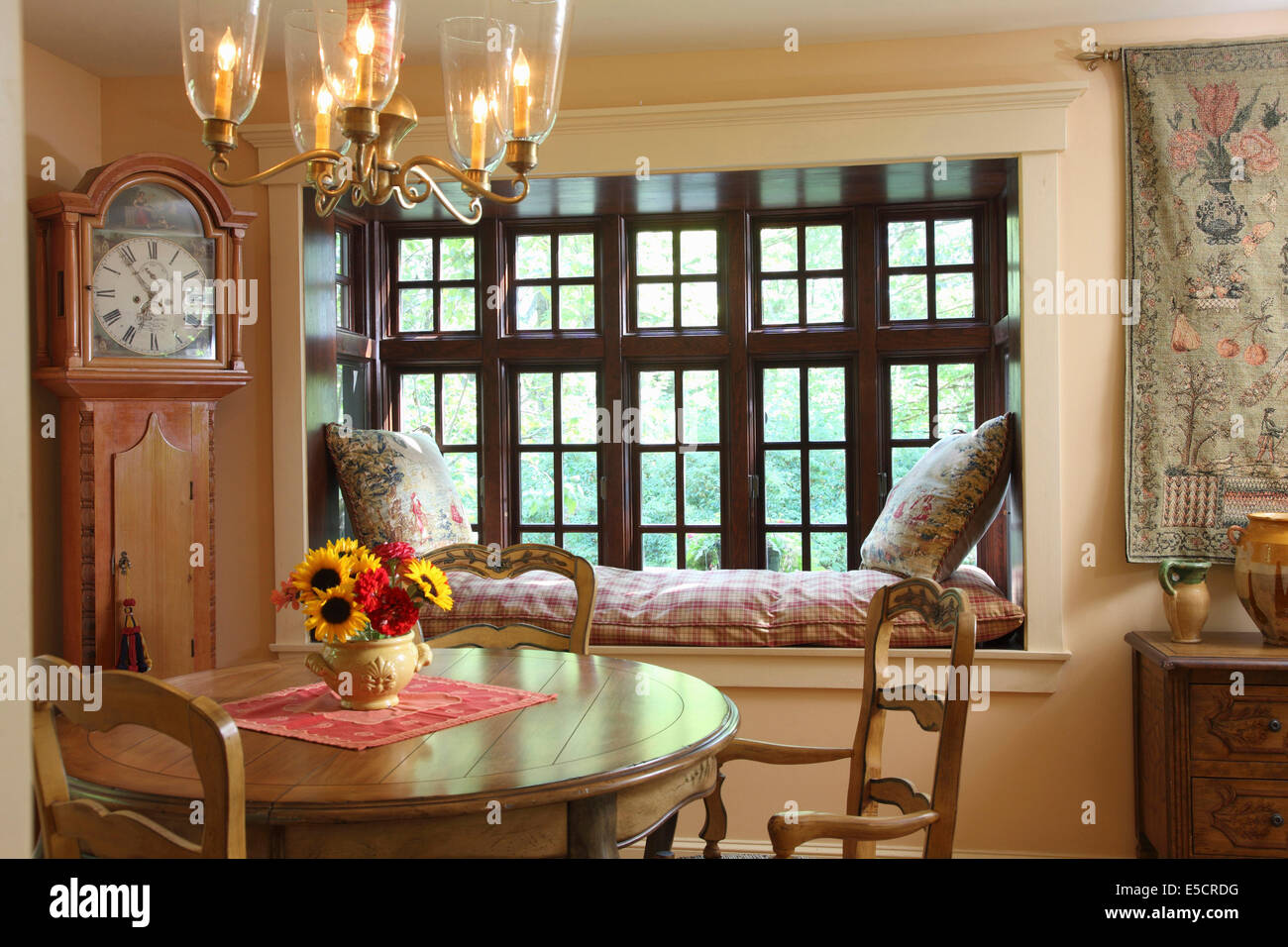 Cozy and romantic dining room, with window seat and grandfather clock, USA. Stock Photo