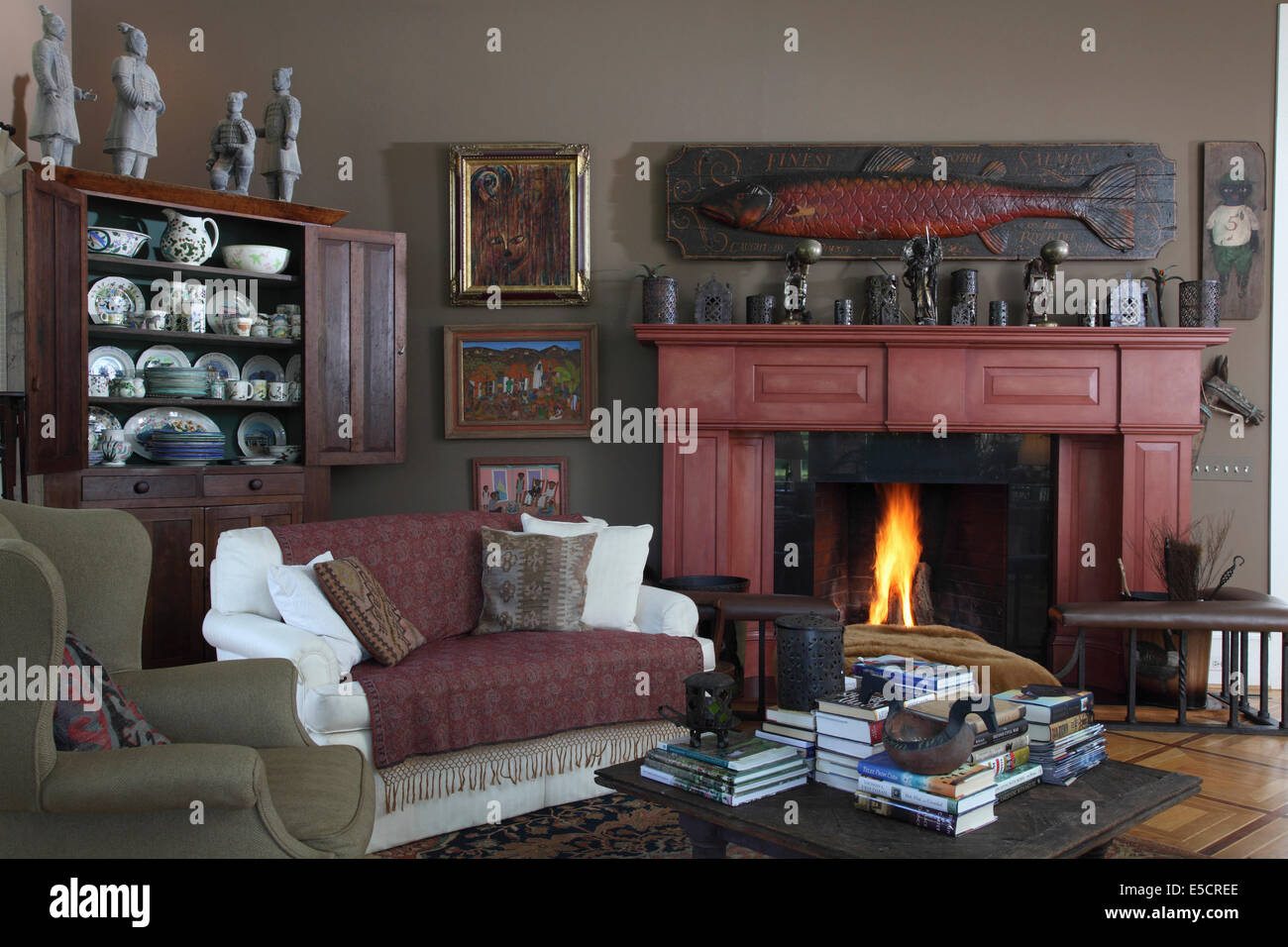 Living room with fireplace and sofa booktable. Folk art paintings and