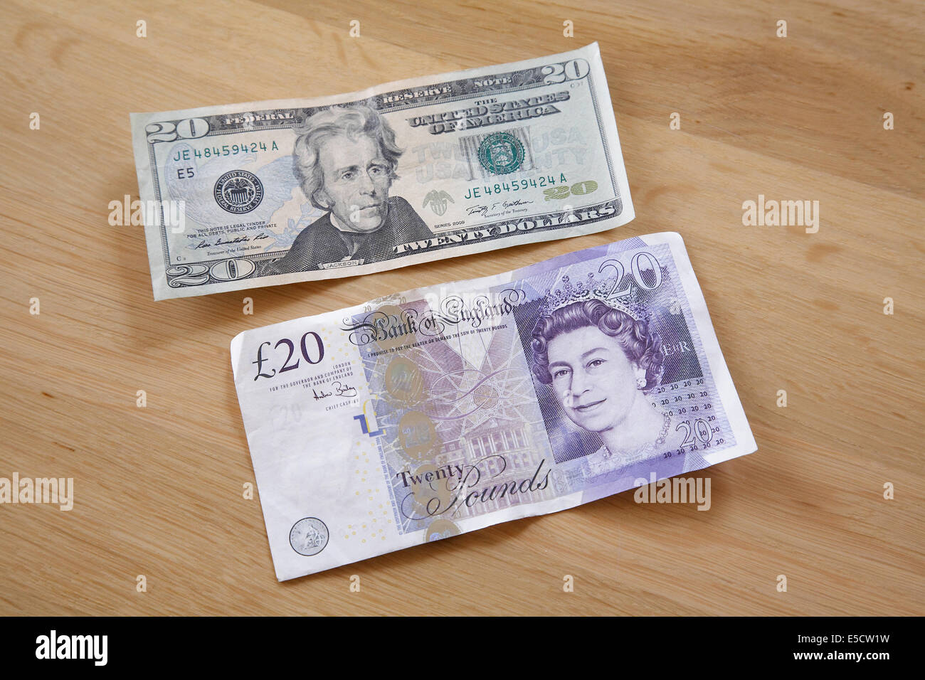 A 20 pound note and 20 dollar bill on a table. Stock Photo