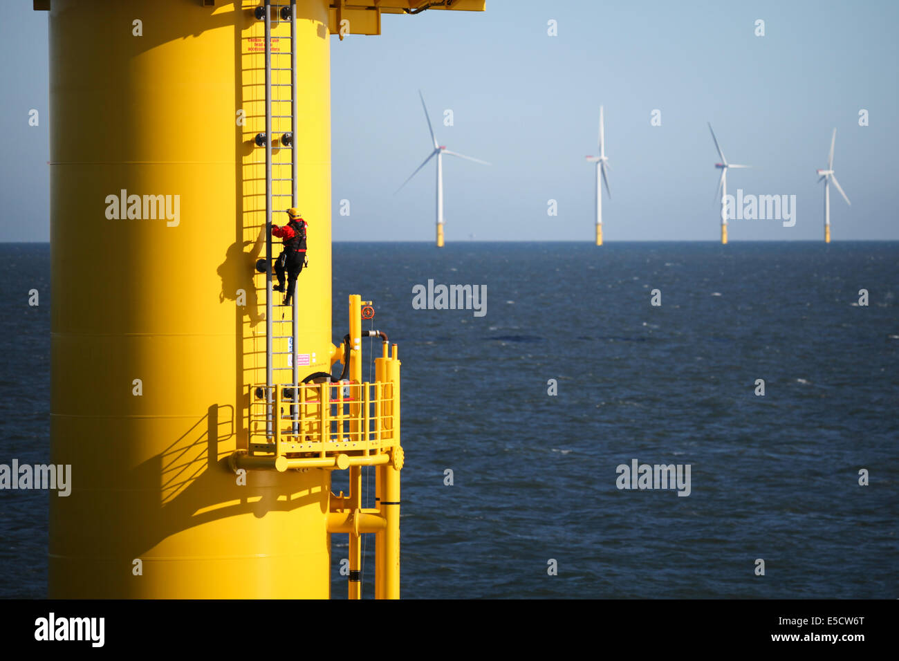 A man climbing a turbine tower on the Gwynt y Mor Wind Farm off the coast of North Wales during the Construction Phase in 2014. Stock Photo
