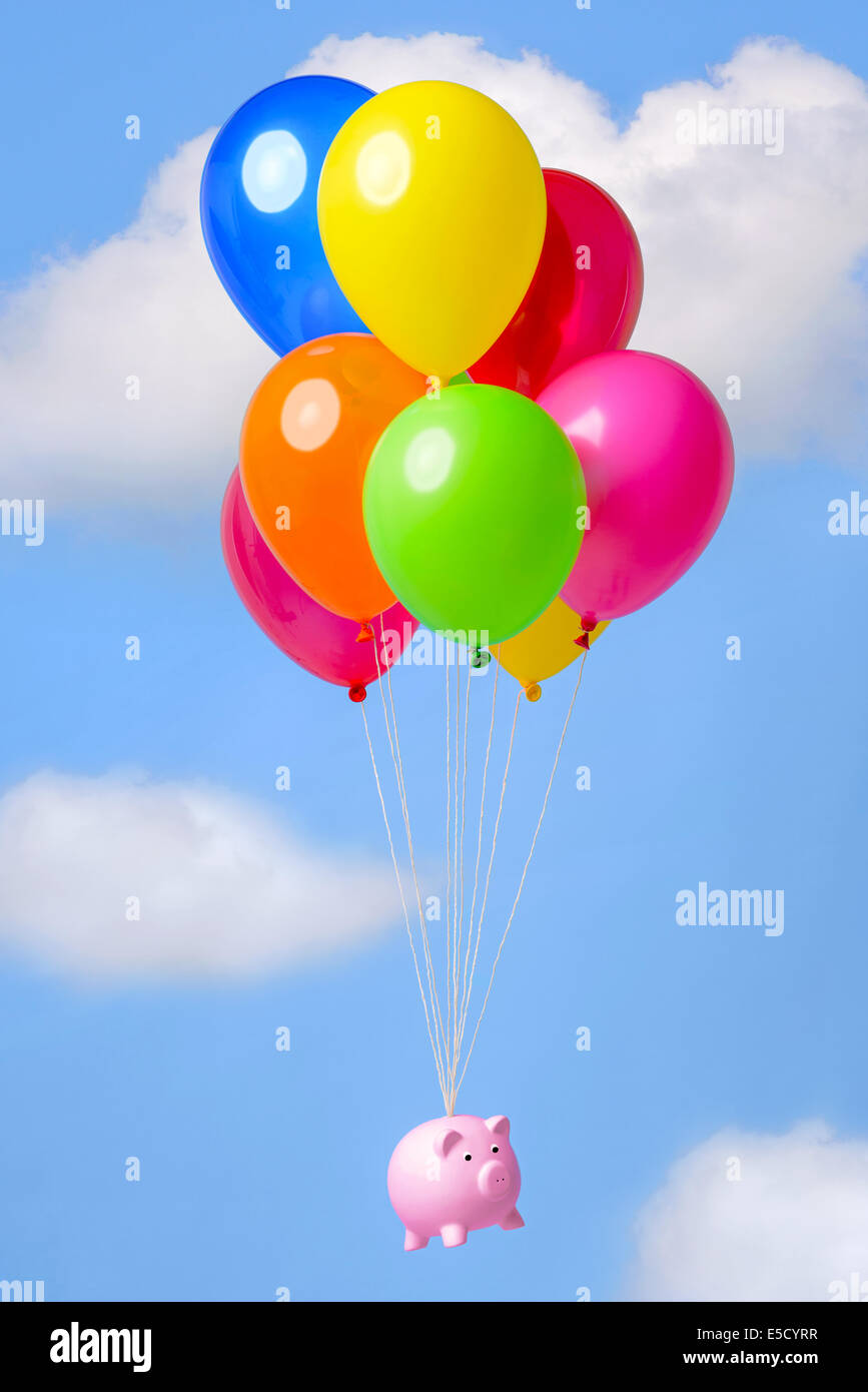 Piggy bank flying in the sky on helium balloons, good image for finance related themes such as Inflation, Savings or Economy. Stock Photo