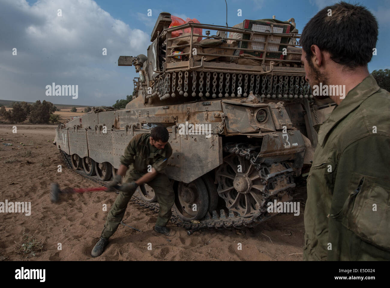 Gaza Border. 28th July, 2014. Israeli soldiers fix the caterpillar track of a Merkava tank in southern Israel near the border with Gaza, on July 28, 2014. The UN Security Council on Monday issued an urgent appeal to Israel and Hamas for an immediate humanitarian truce in Gaza, where more than 1,030 Palestinians and 43 Israeli soldiers were killed over the past few weeks. Credit:  Li Rui/Xinhua/Alamy Live News Stock Photo