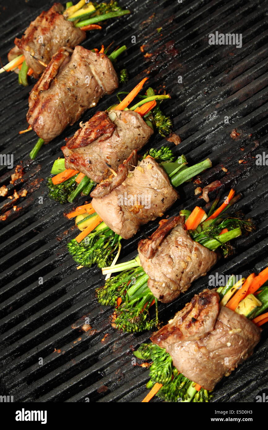 Crispy vegetables wrapped in steak cooking on the bbq Stock Photo Alamy