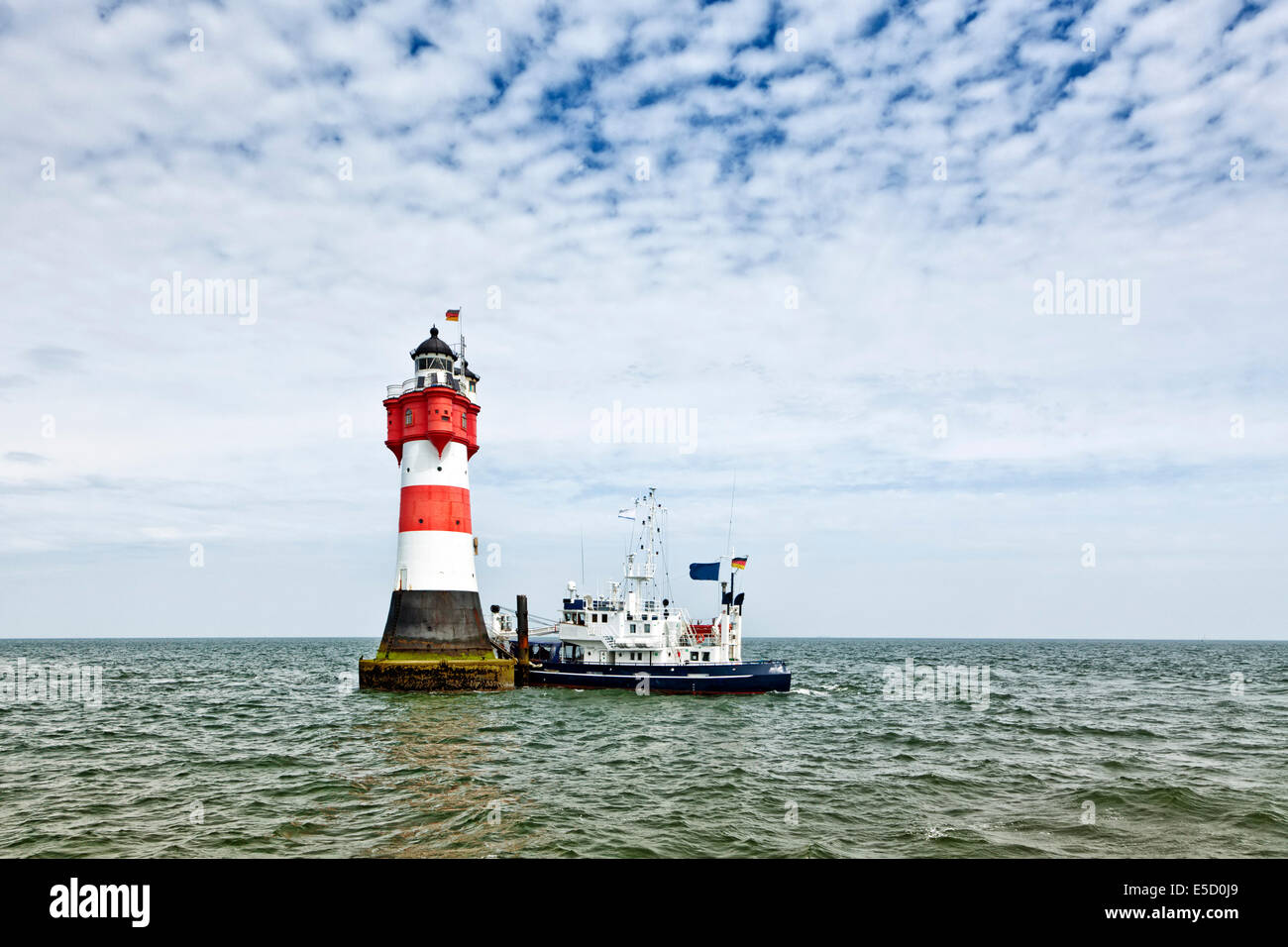 Supply ship moored at Roter Sand lighthouse in the Weser estuary Stock Photo