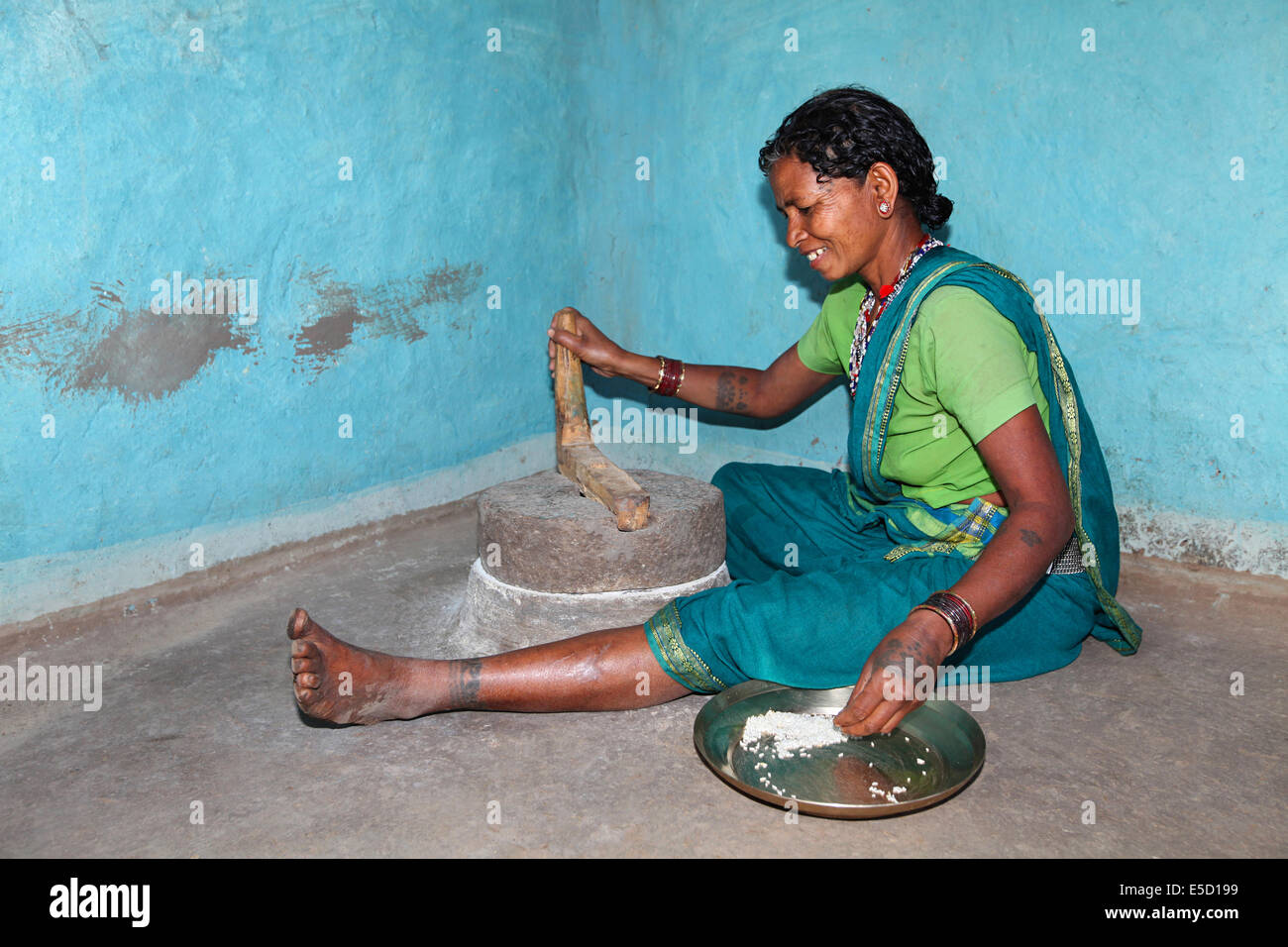 Tribal woman grinding rice, Baiga tribe. Karangra Village, Chattisgadh, India Stock Photo