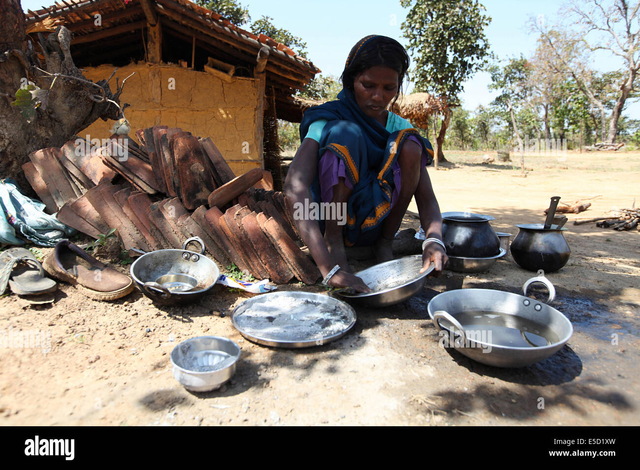 Tribal women cleaning utensils. Birhor tribe. Chueya Village, Korba District, Chattisgadh, India Stock Photo