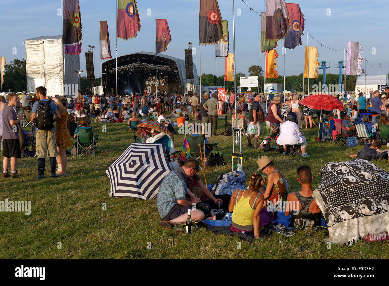 People relaxing in summer sunshine, Open Air Stage, WOMAD 2014, England, UK, GB. Stock Photo