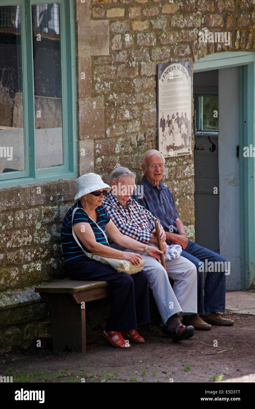 Pensioners sitting outside Tyneham School at Tyneham Village, Dorset UK in July - lost abandoned deserted village Stock Photo