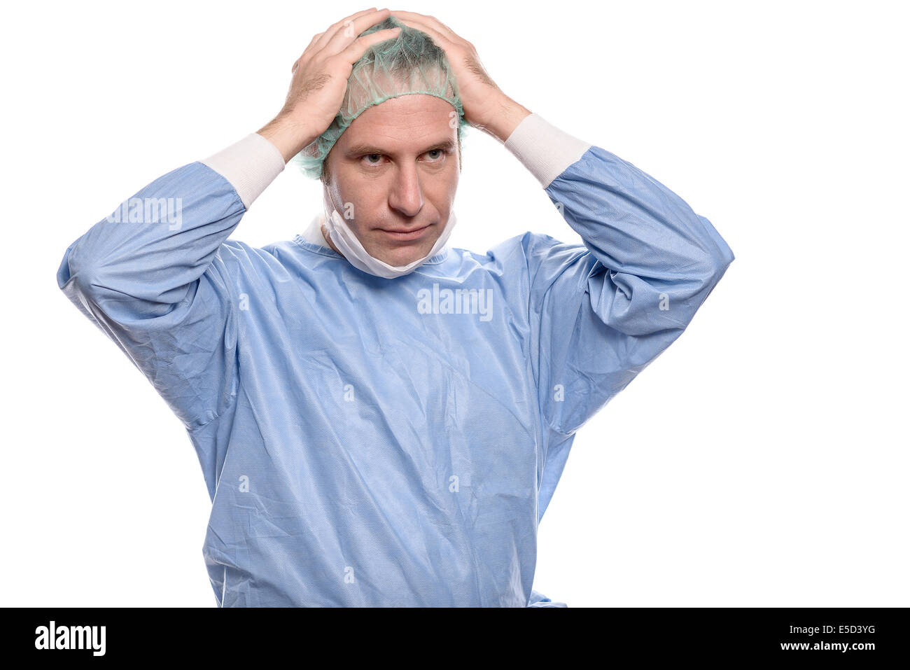 Depressed surgeon in theater garb or scrubs holding his hands to his head with a grim expression isolated on white Stock Photo
