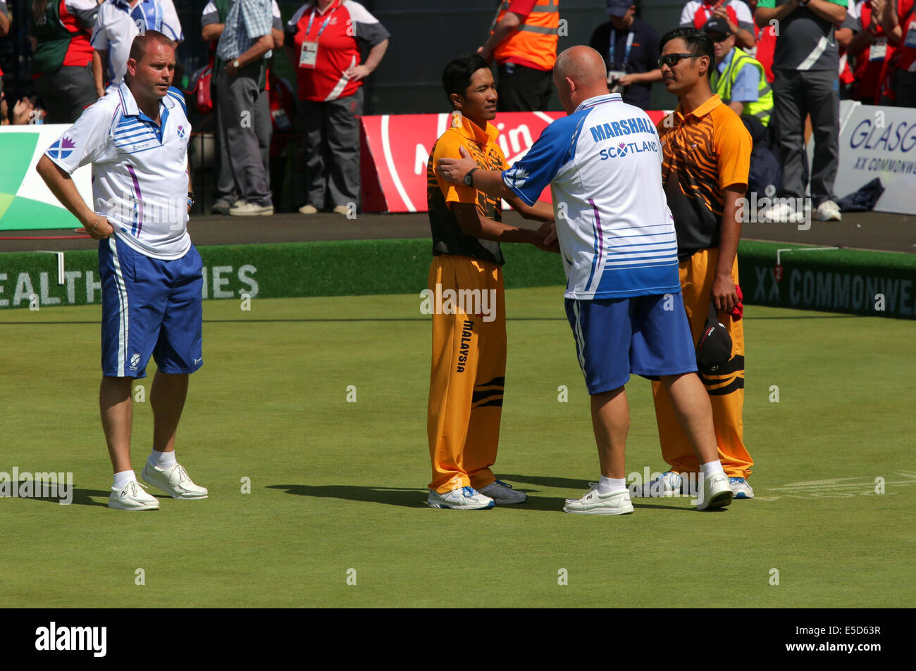 Kelvingrove Lawn Bowls Centre, Glasgow, Scotland, UK, Monday, 28th July, 2014. Players shake hands at the end of the Men's Lawn Bowls Pairs Final between Scotland's Paul Foster and Alex Marshall and Malaysia's Muhammad Hizlee Abdul Rais and Fairul Izwan Abd Muin which Scotland won at the Glasgow 2014 Commonwealth Games Stock Photo