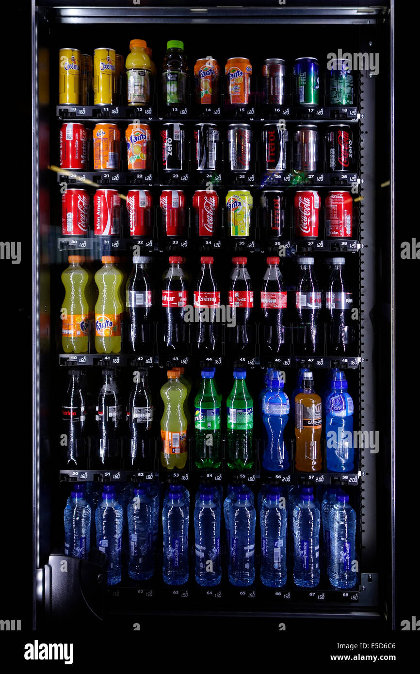 Various brands of refreshing non-alcoholic soft drinks, coke, lemonades and water on display in automatic vending machine Stock Photo