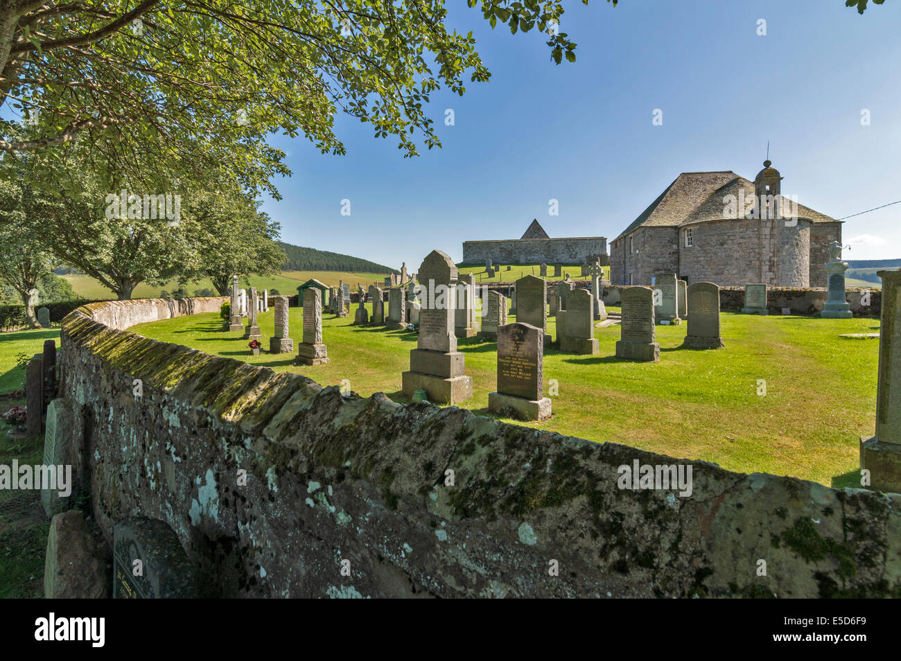 KILDRUMMY SCOTLAND THE NEW CHURCH WITH BELL TOWER AND THE OLD KIRK WALL ON THE MOUND BEHIND Stock Photo