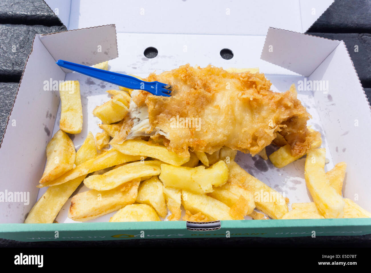 Take away Fish and Chips in a cardboard box on a wooden table top Stock