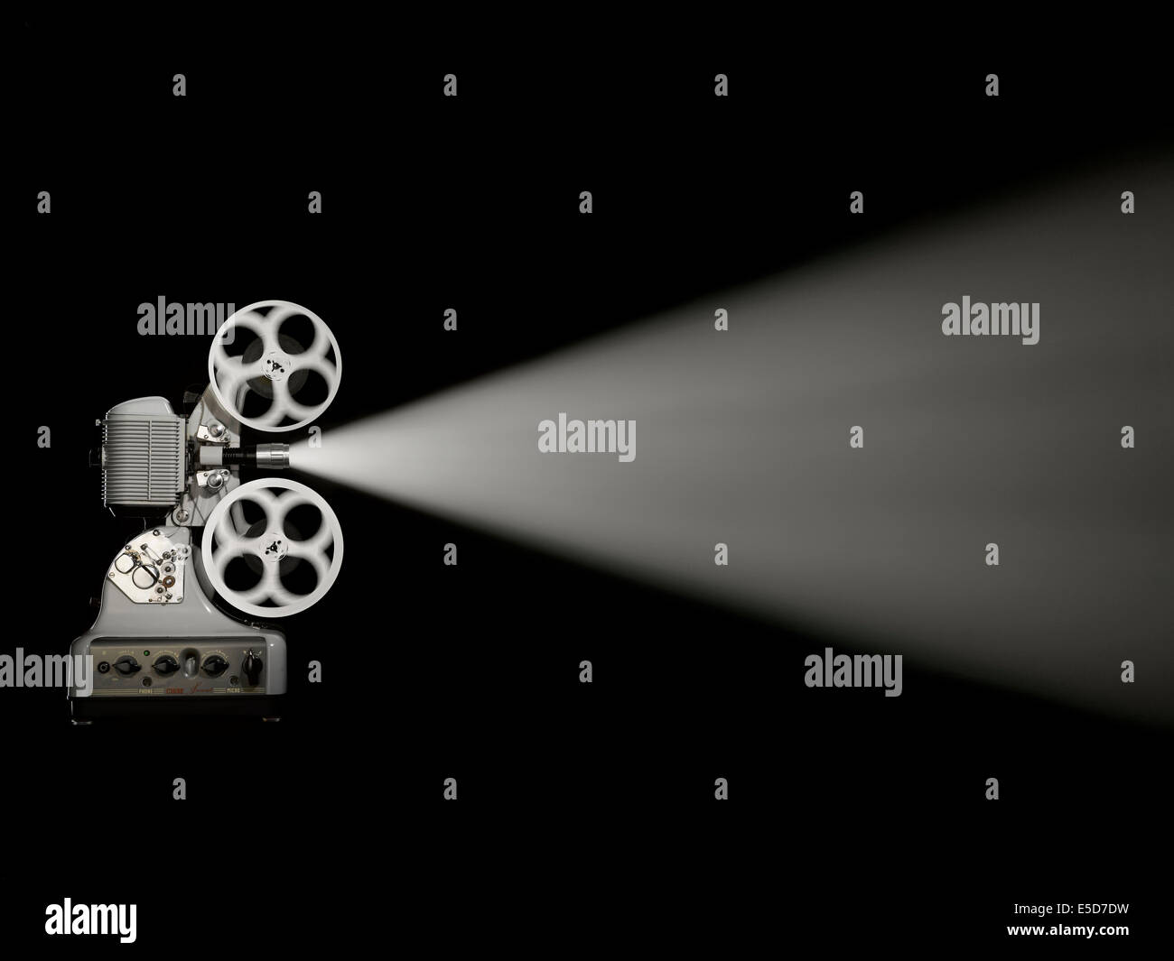 A side shot of an old style film projector on a black background Stock Photo
