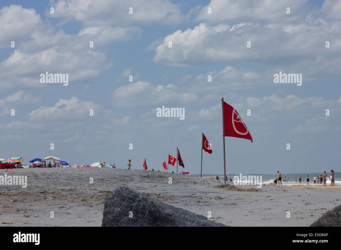 Windy day at Vilano Beach; Rocks, surfing, warning flags; people on
