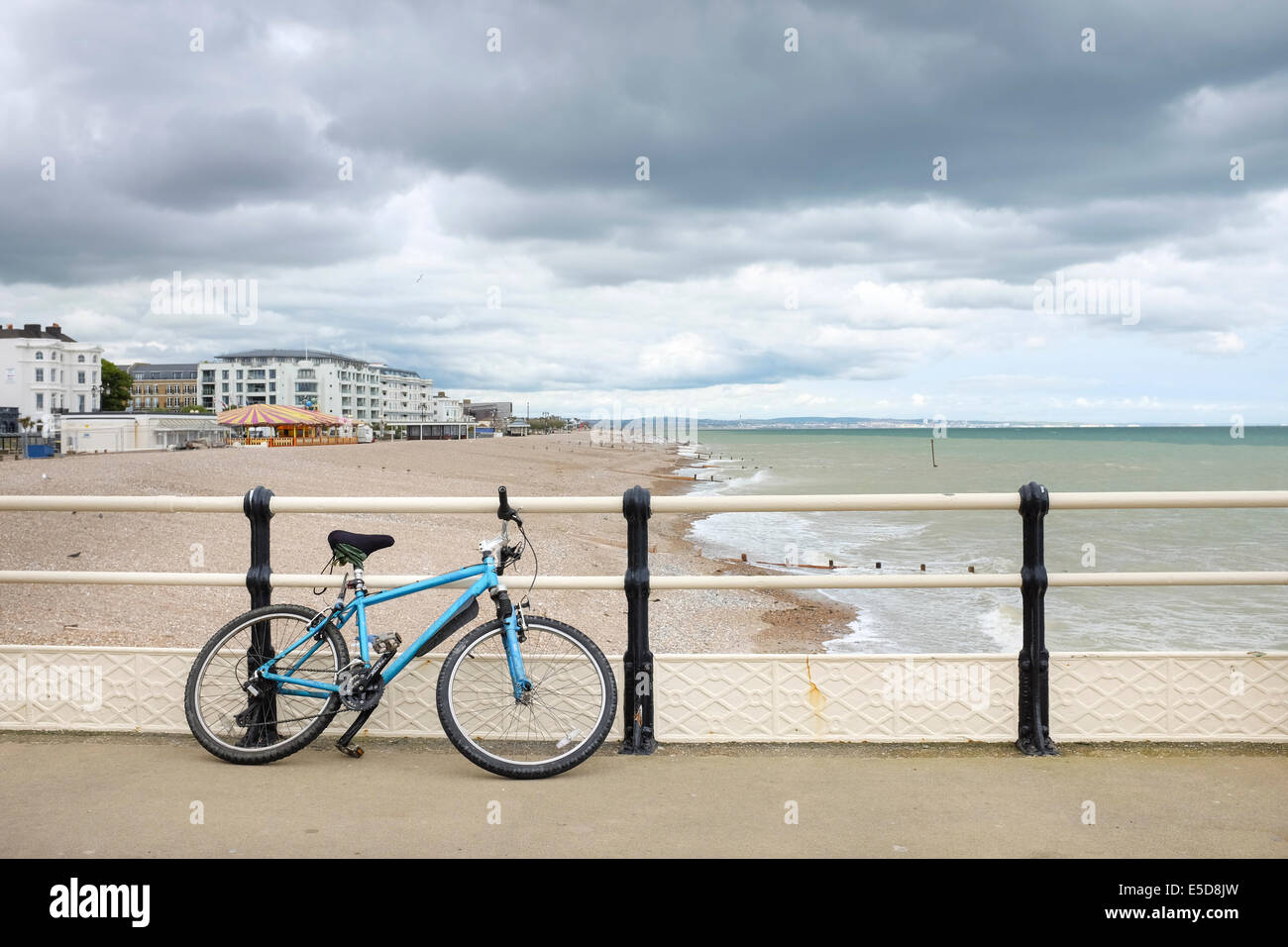Blue bicycle leaning against a railing on the Worthing Pier, UK Stock Photo