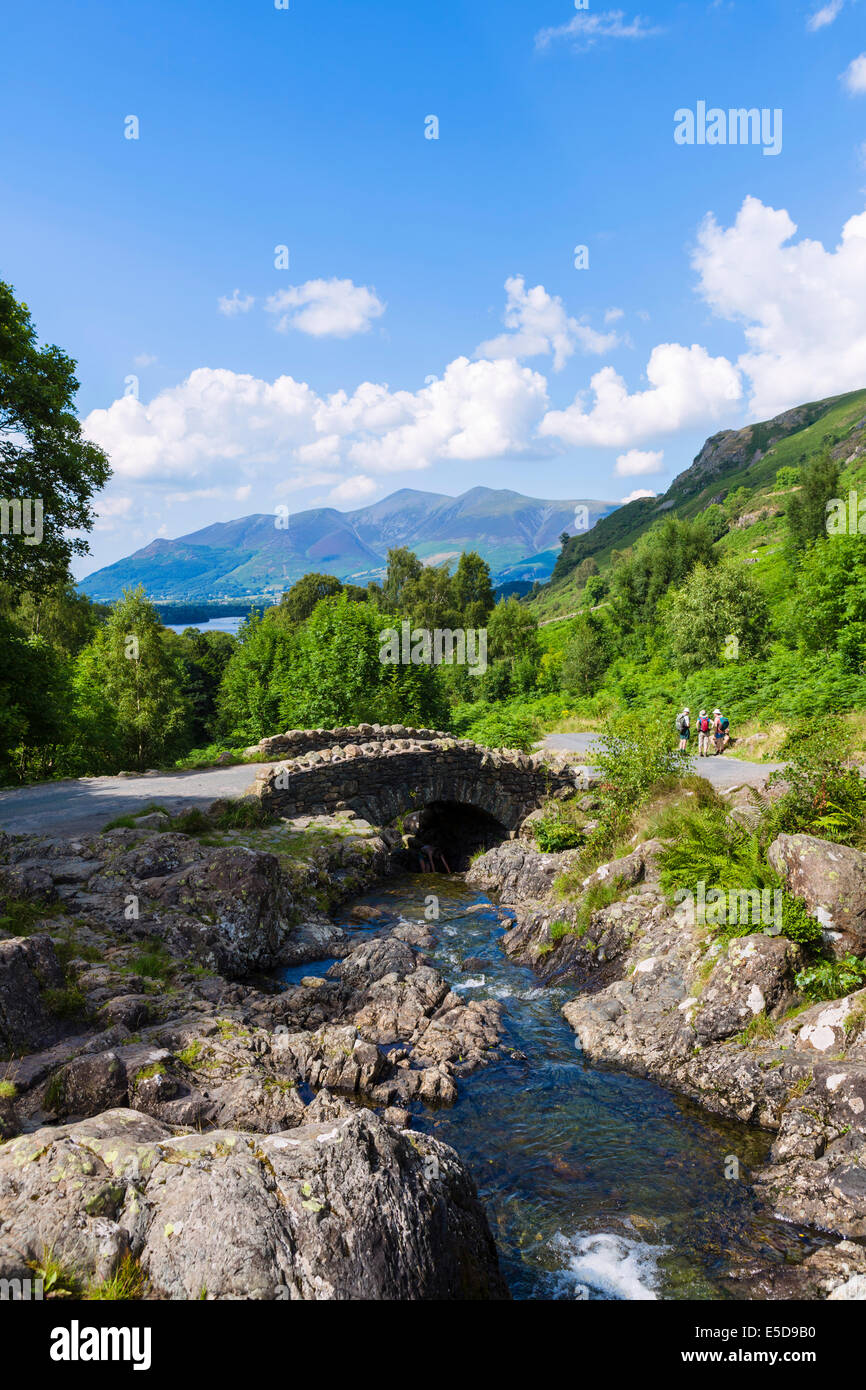 Walkers at Ashness Bridge with Skiddaw massif in the distance, Borrowdale, Lake District, Cumbria, UK Stock Photo