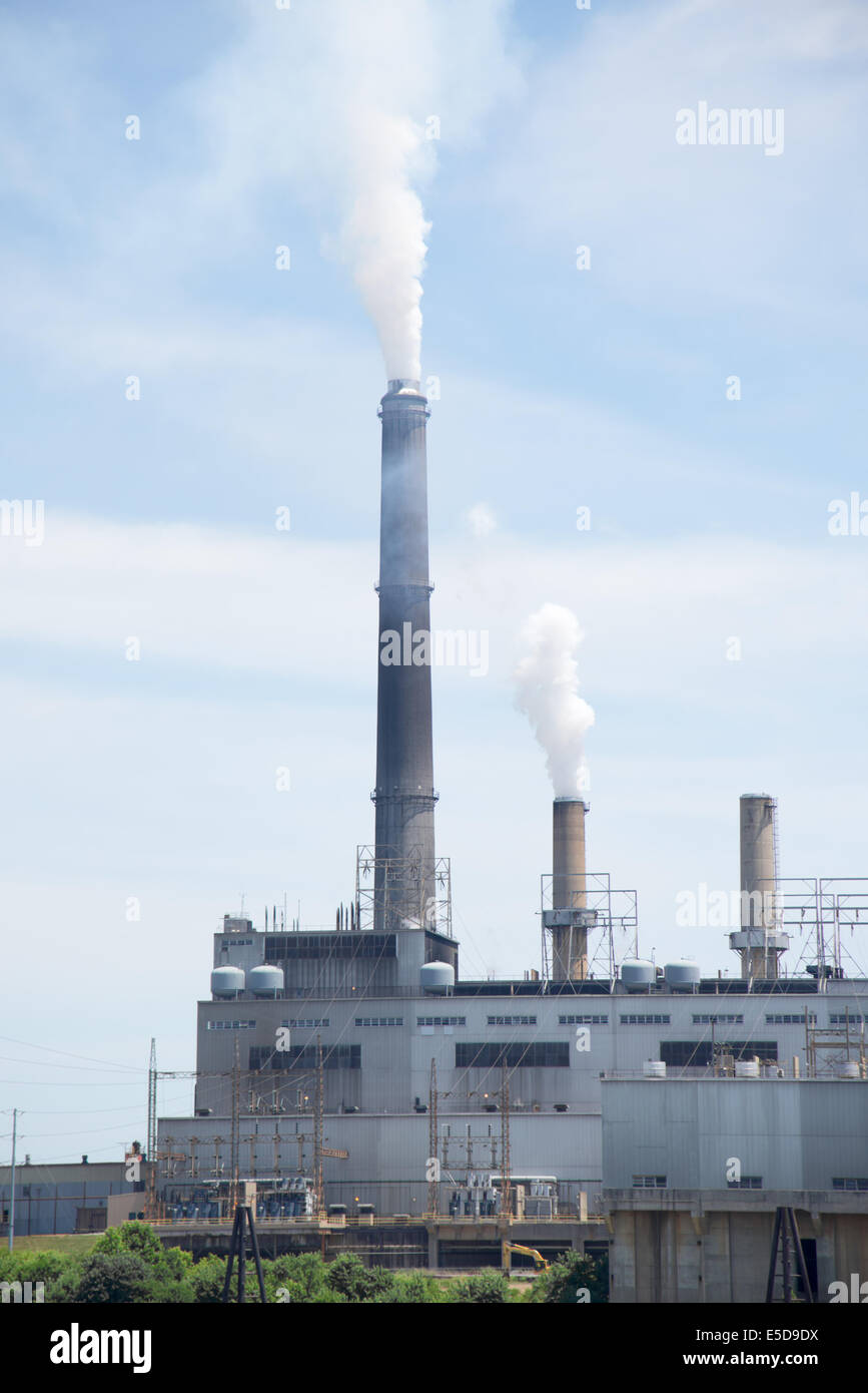 A factory pollutes the sky with exhaust and emissions from smoke stack Stock Photo