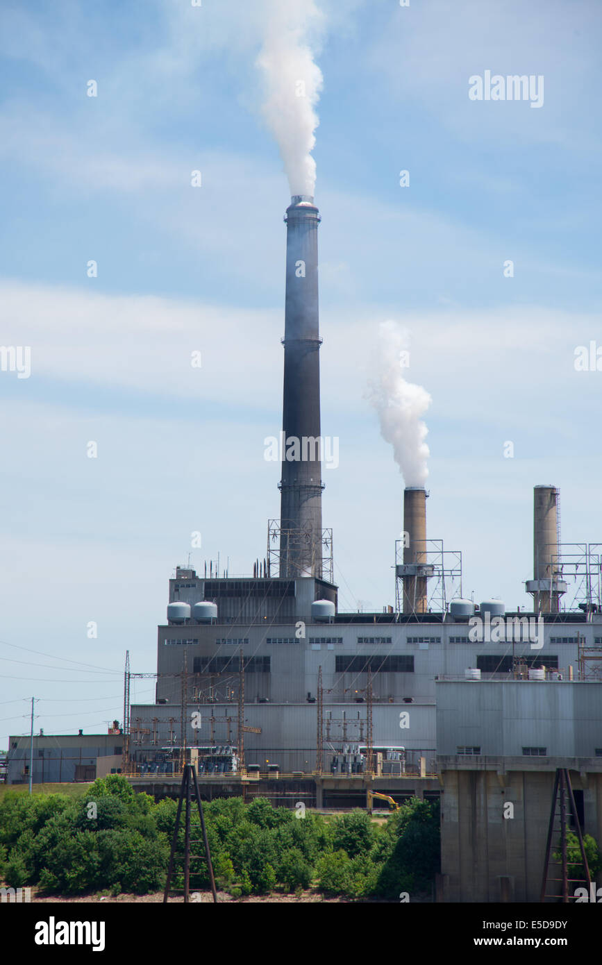 A factory pollutes the sky with exhaust and emissions from smoke stack Stock Photo