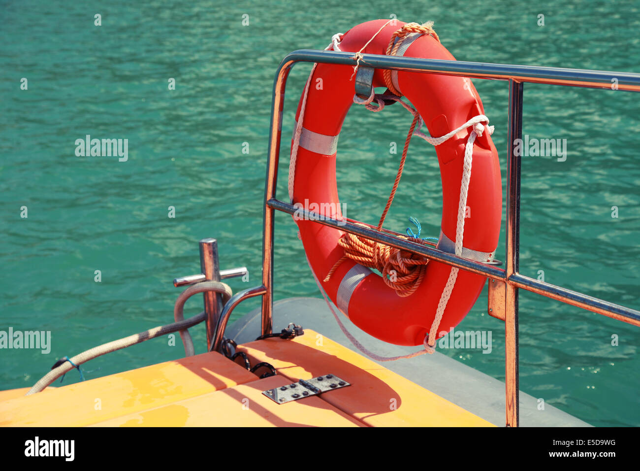 Red lifebuoy hanging on railings of safety rescue boat Stock Photo