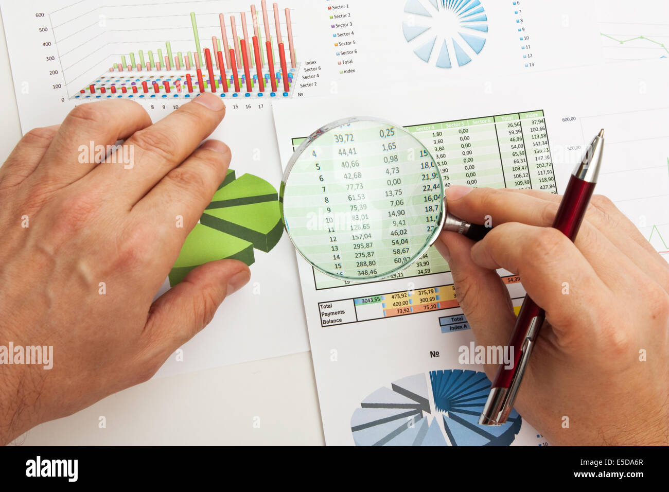 magnifying glass in hand and working paper chart Stock Photo - Alamy